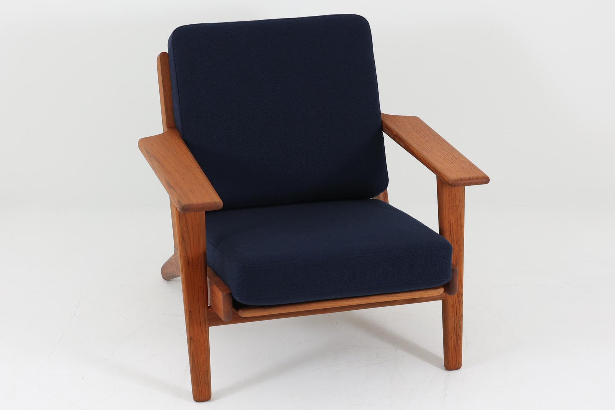 北欧家具を代表するソファ『GE290』です。現在リプロダクト品が販売されていますが、こちらは本物です。元々はベッド会社であるGETAmA社ならではのコイルスプリングが内包されたクッションの座り心地は、弾力があり心地良く、読書や映画などのリラックスタイムに最適です。立ち上がる際も適度なはね返りがあるので、動く時に億劫になる事はありません。Hans J. Wegnerならではの時代を超えた美しいデザインも魅力のひとつ。横や背面から眺めると、また異なる表情が楽しめます。さらに、こちらは現行品では手に入らない希少なチーク材モデル。素材の質感と温かみを存分に味わえる逸品です。