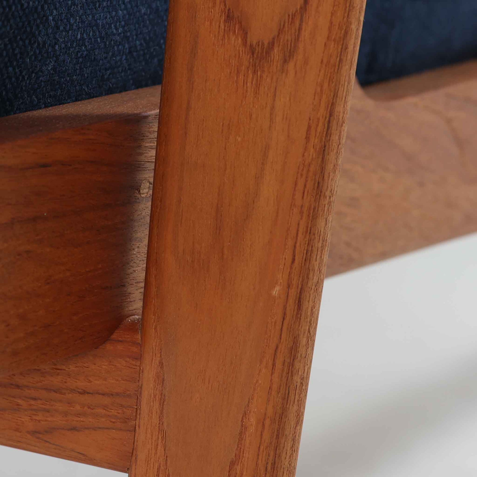 Hans J. Wegnerがデザインし、Getama社によって製造されたGe290Aは、現在では希少となったチーク材のフレームに深いブルーの張地が美しく調和した、ハイバック仕様のビンテージシングルソファです。緩やかに傾斜する背もたれと幅広のアームが身体を包み込むような快適な座り心地を実現し、日常に上質な寛ぎをもたらします。背面の格子状フレームや真鍮ビスなど、細部にまでウェグナーの美意識が宿り、北欧家具の名作としてリビングの主役にふさわしい存在感を放ちます。座面クッションにはスプリングが内包されていますが、背もたれにはウレタンのみが使用されています。