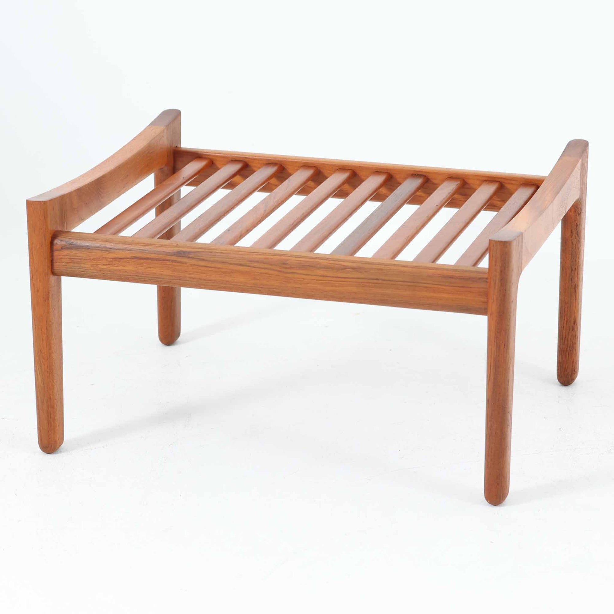 Hans J. Wegnerがデザインし、Getama社によって製造されたGE290オットマンは、堅牢なチーク無垢材のフレームと、美しい格子状のベース構造が特徴の名作です。チーク材仕様のモデルは現存数が少なく、希少価値の高い一台となっています。クッション内部にはスプリングが内包されており、張地にはアクリルとウールを混紡したグリーン系のファブリックが使用され、やわらかな風合いと快適な座り心地を実現。単体でも、同シリーズのソファと組み合わせても使いやすく、北欧ビンテージらしい実用性と美しさを兼ね備えています。