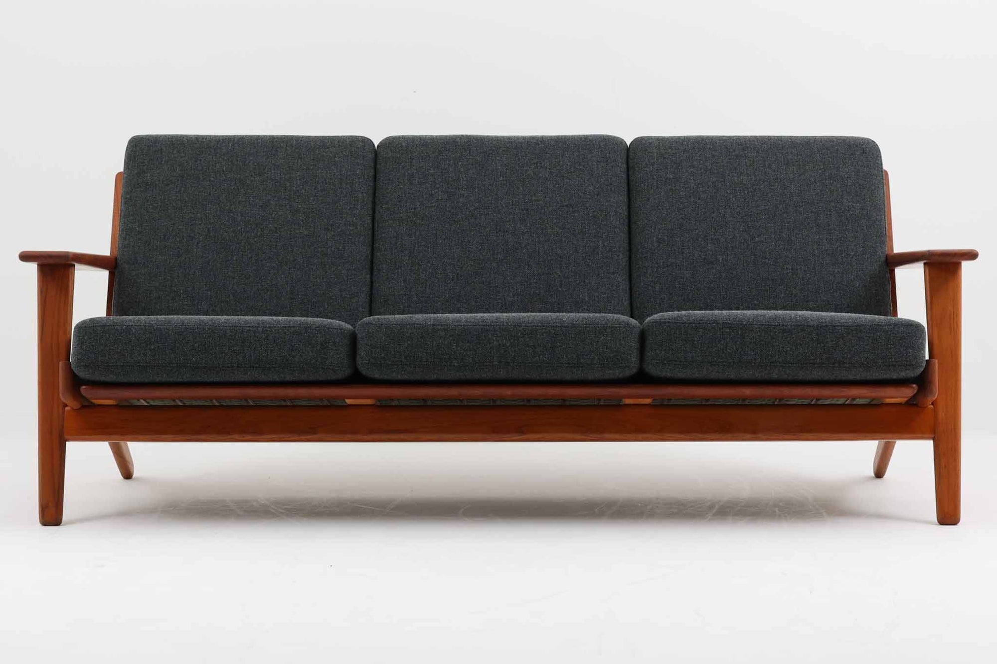 北欧家具を代表するソファ『GE290』です。現在リプロダクト品が販売されていますが、こちらは本物です。元々はベッド会社であるGETAmA社ならではのコイルスプリングが内包されたクッションの座り心地は、弾力があり心地良く、読書や映画などのリラックスタイムに最適です。立ち上がる際も適度なはね返りがあるので、動く時に億劫になる事はありません。Hans J. Wegnerならではの時代を超えた美しいデザインも魅力のひとつ。横や背面から眺めると、また異なる表情が楽しめます。さらに、こちらは現行品では手に入らない希少なチーク材モデル。素材の質感と温かみを存分に味わえる逸品です。