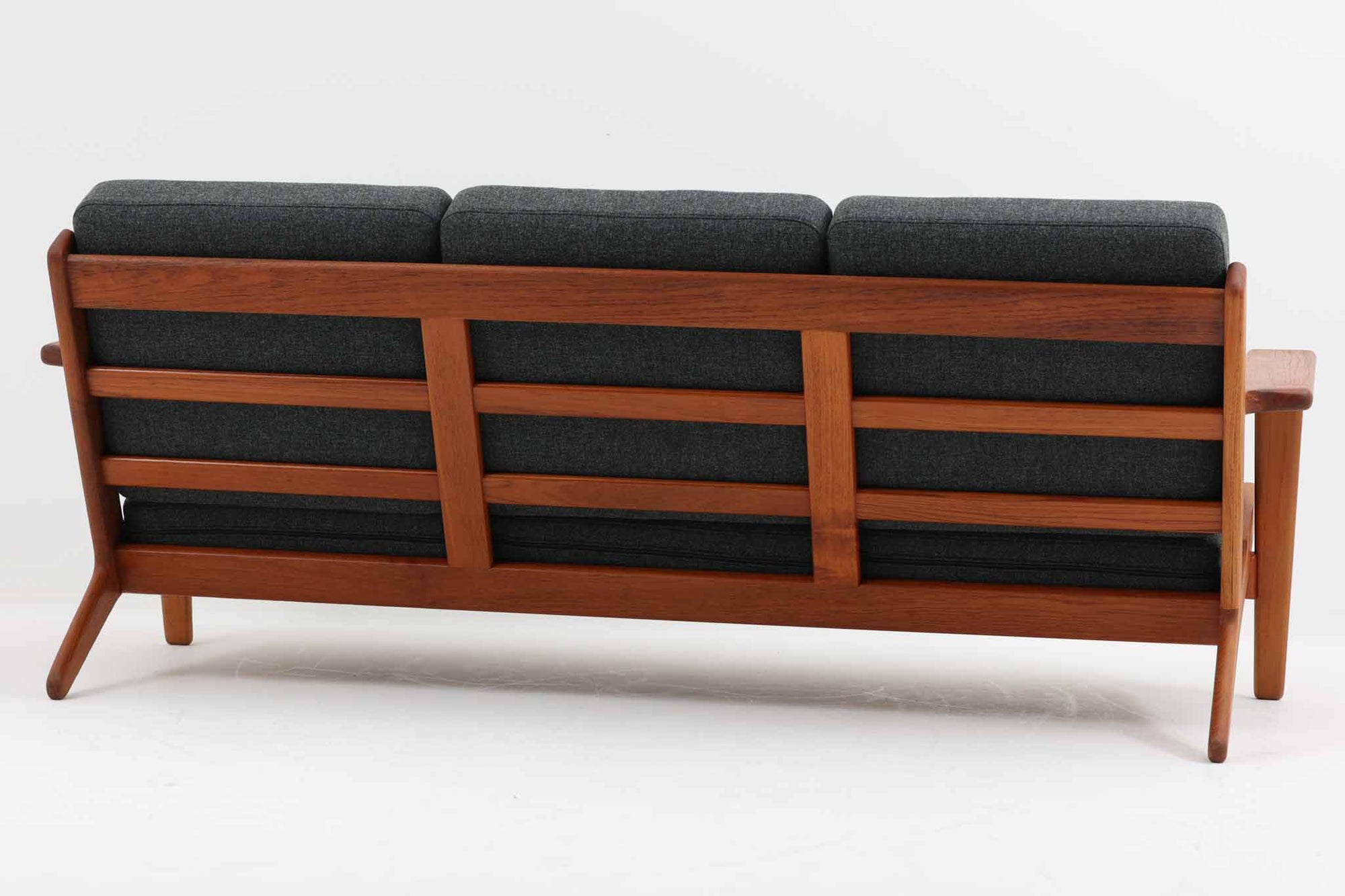 北欧家具を代表するソファ『GE290』です。現在リプロダクト品が販売されていますが、こちらは本物です。元々はベッド会社であるGETAmA社ならではのコイルスプリングが内包されたクッションの座り心地は、弾力があり心地良く、読書や映画などのリラックスタイムに最適です。立ち上がる際も適度なはね返りがあるので、動く時に億劫になる事はありません。Hans J. Wegnerならではの時代を超えた美しいデザインも魅力のひとつ。横や背面から眺めると、また異なる表情が楽しめます。さらに、こちらは現行品では手に入らない希少なチーク材モデル。素材の質感と温かみを存分に味わえる逸品です。