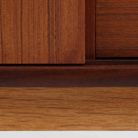 デンマーク製の小ぶりな北欧ビンテージボードで、チーク材とオーク材の組み合わせが上品な一台です。幅90cmとコンパクトながら、引き出し4杯とスライド扉付きの収納部を備え、実用性に優れています。丸いくり抜きの取っ手や直線的な脚部のデザインが軽快な印象を与え、どんな空間にも馴染みやすい造りです。背面の収納部には配線用の穴があり、オーディオや小型テレビ台としても活用可能です。経年により深みを増した木肌が、北欧家具ならではの味わいを感じさせます。