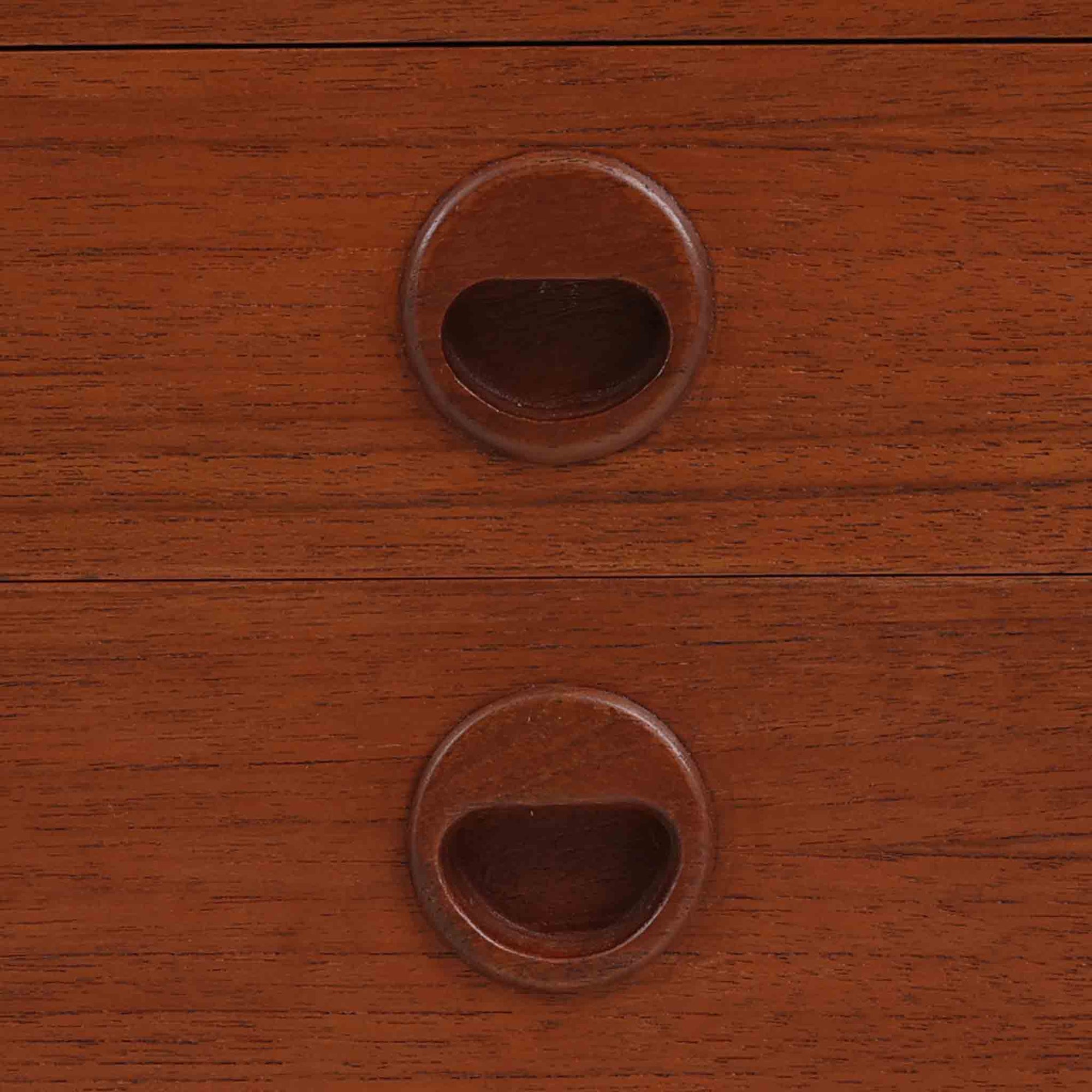 デンマーク製の小ぶりな北欧ビンテージボードで、チーク材とオーク材の組み合わせが上品な一台です。幅90cmとコンパクトながら、引き出し4杯とスライド扉付きの収納部を備え、実用性に優れています。丸いくり抜きの取っ手や直線的な脚部のデザインが軽快な印象を与え、どんな空間にも馴染みやすい造りです。背面の収納部には配線用の穴があり、オーディオや小型テレビ台としても活用可能です。経年により深みを増した木肌が、北欧家具ならではの味わいを感じさせます。