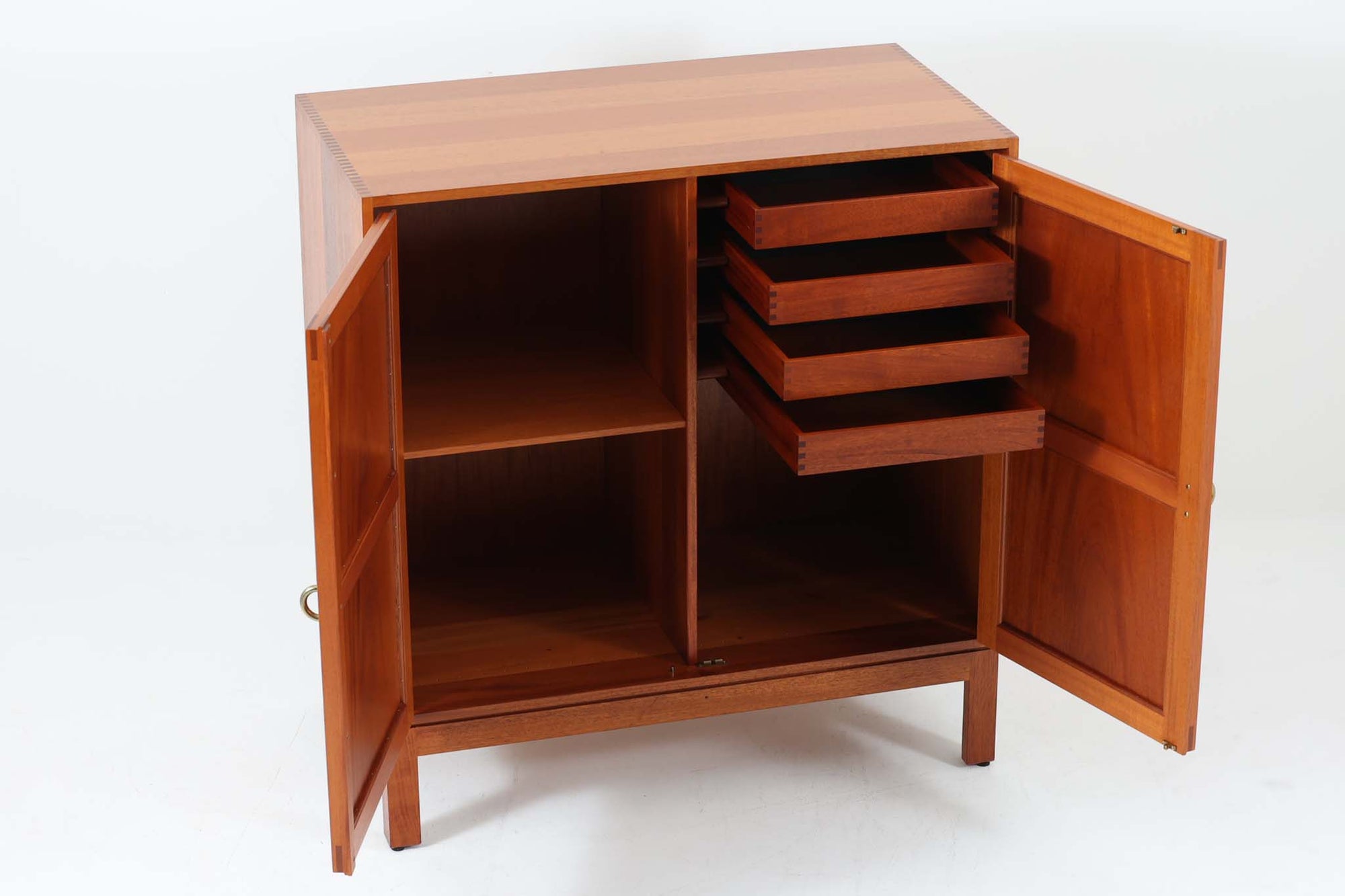 ビンテージ北欧家具の名門、デンマークのSoborg mobler社が手掛けたキャビネットです。デザイナーはChristian Hvidt（クリスチャン・ヴィッツ）。上質なマホガニー無垢材を贅沢に使用し、美しい木目と落ち着いた色合いが特徴的です。扉の意匠は4枚のパネルで構成され、シンプルながらも端正な印象を与えます。内部は左側に棚板、右側に引き出しを配置した実用的な収納設計。特にフレームや引き出しには指物（さしもの）による堅牢な組み方が施されており、デンマークの確かな家具製作技術を感じられます。脚付きのスタイルは床との間に適度な空間を作り出し、重厚な本体でありながら軽やかな印象を演出しています。リビングやダイニングルームでの使用に最適な、機能性とデザイン性を兼ね備えた逸品です。