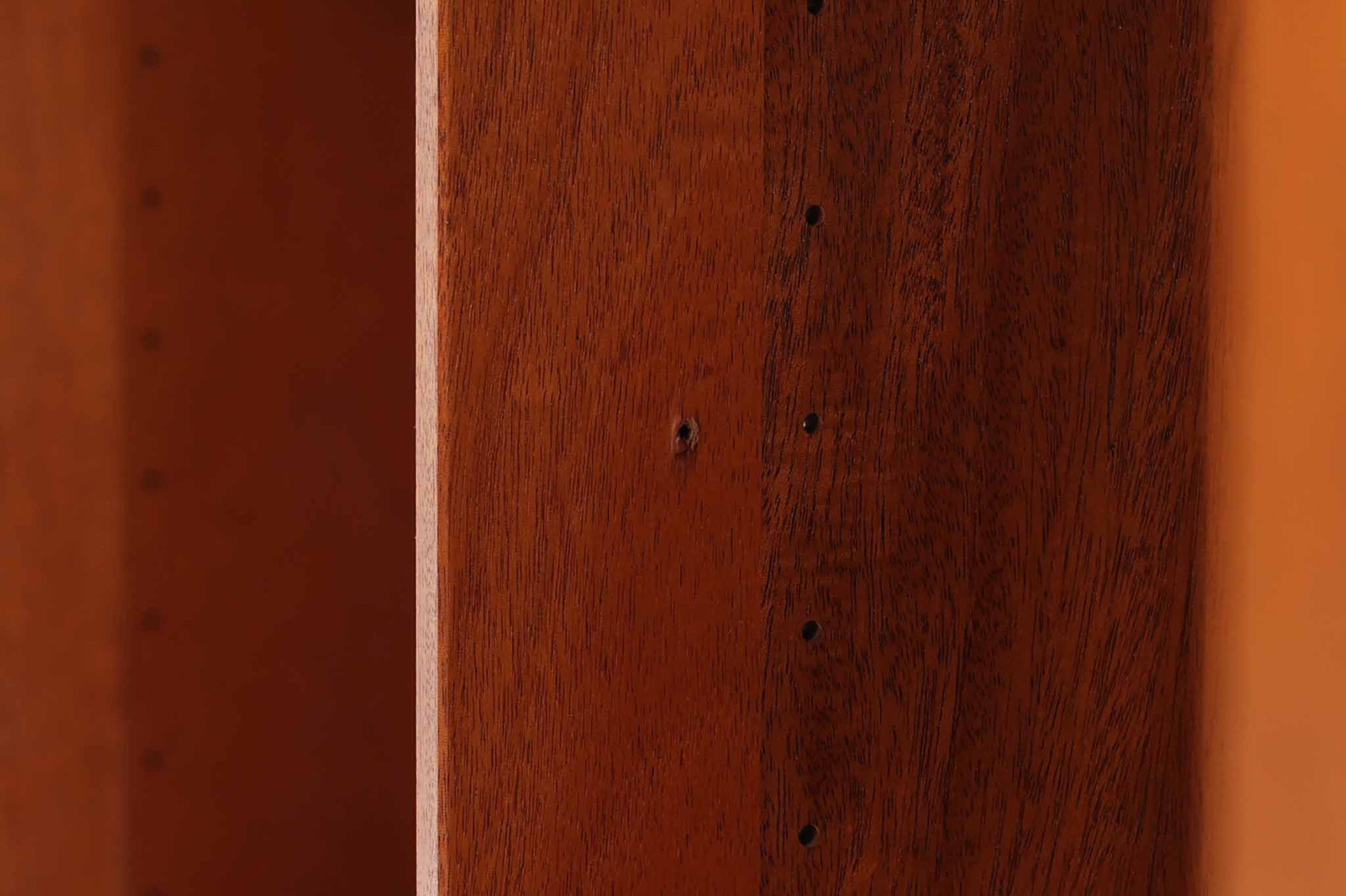 ビンテージ北欧家具の名門、デンマークのSoborg mobler社が手掛けたキャビネットです。デザイナーはChristian Hvidt（クリスチャン・ヴィッツ）。上質なマホガニー無垢材を贅沢に使用し、美しい木目と落ち着いた色合いが特徴的です。扉の意匠は4枚のパネルで構成され、シンプルながらも端正な印象を与えます。内部は左側に棚板、右側に引き出しを配置した実用的な収納設計。特にフレームや引き出しには指物（さしもの）による堅牢な組み方が施されており、デンマークの確かな家具製作技術を感じられます。脚付きのスタイルは床との間に適度な空間を作り出し、重厚な本体でありながら軽やかな印象を演出しています。リビングやダイニングルームでの使用に最適な、機能性とデザイン性を兼ね備えた逸品です。