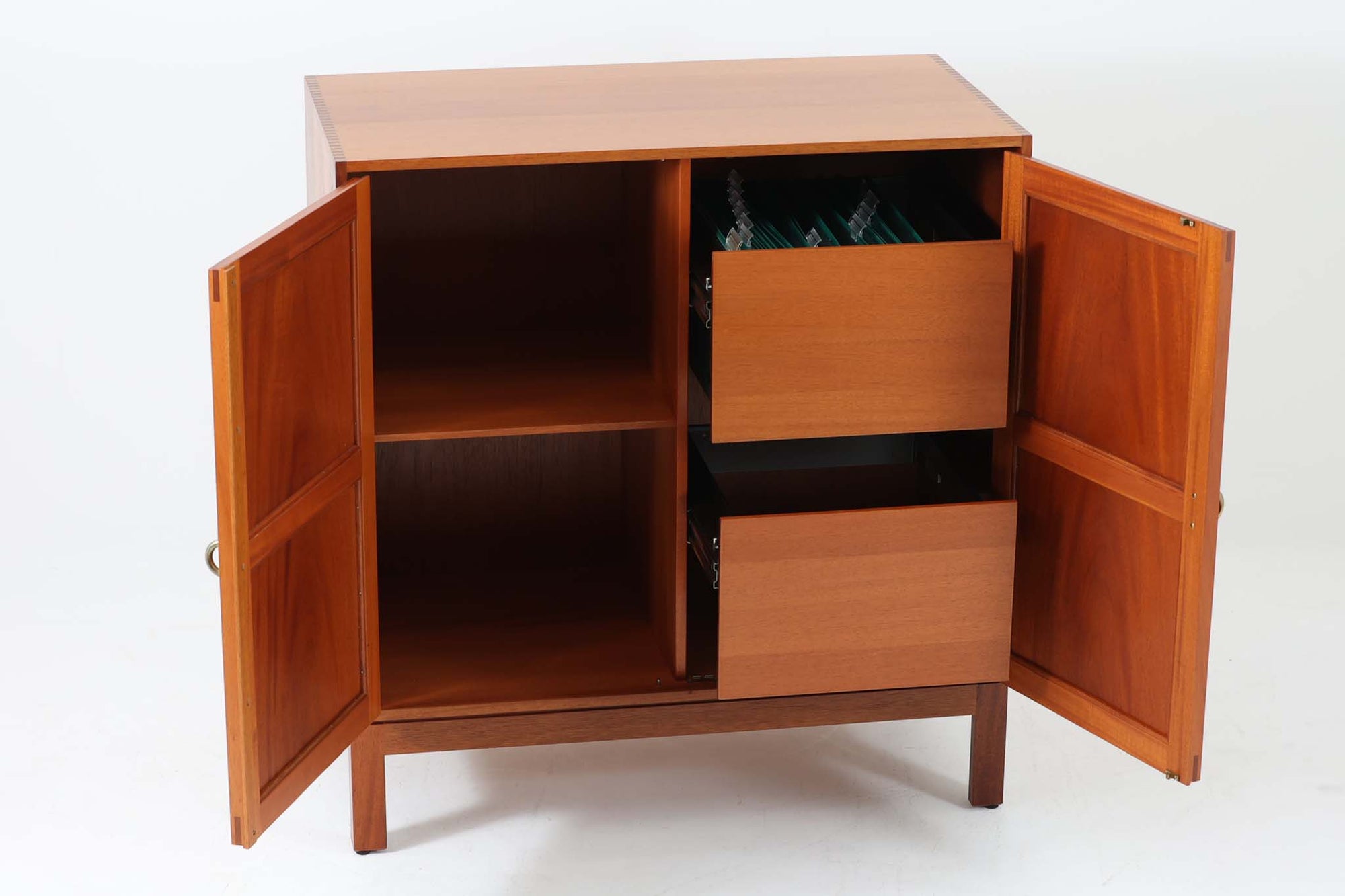 ビンテージ北欧家具の名門、デンマークのSoborg mobler社が手掛けたキャビネットです。デザイナーはChristian Hvidt（クリスチャン・ヴィッツ）。上質なマホガニー無垢材を贅沢に使用し、美しい木目と落ち着いた色合いが特徴的です。扉の意匠は4枚のパネルで構成され、シンプルながらも端正な印象を与えます。内部は左側に棚板、右側にファイルドロワーを配置した実用的な収納設計。特にフレームには指物（さしもの）による堅牢な組み方が施されており、デンマークの確かな家具製作技術を感じられます。脚付きのスタイルは床との間に適度な空間を作り出し、重厚な本体でありながら軽やかな印象を演出しています。リビングやダイニングルームでの使用に最適な、機能性とデザイン性を兼ね備えた逸品です。