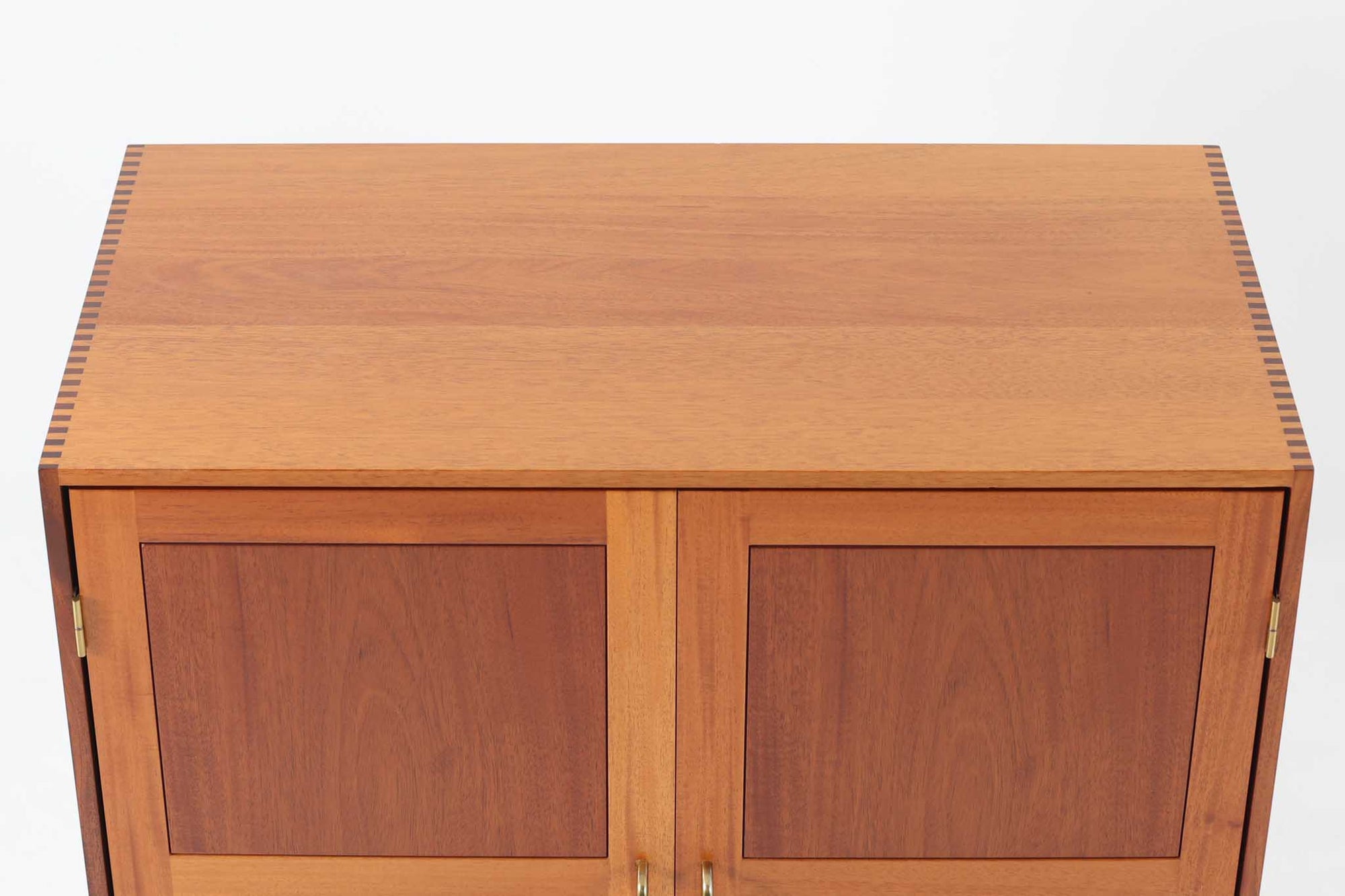 ビンテージ北欧家具の名門、デンマークのSoborg mobler社が手掛けたキャビネットです。デザイナーはChristian Hvidt（クリスチャン・ヴィッツ）。上質なマホガニー無垢材を贅沢に使用し、美しい木目と落ち着いた色合いが特徴的です。扉の意匠は4枚のパネルで構成され、シンプルながらも端正な印象を与えます。内部は左側に棚板、右側にファイルドロワーを配置した実用的な収納設計。特にフレームには指物（さしもの）による堅牢な組み方が施されており、デンマークの確かな家具製作技術を感じられます。脚付きのスタイルは床との間に適度な空間を作り出し、重厚な本体でありながら軽やかな印象を演出しています。リビングやダイニングルームでの使用に最適な、機能性とデザイン性を兼ね備えた逸品です。