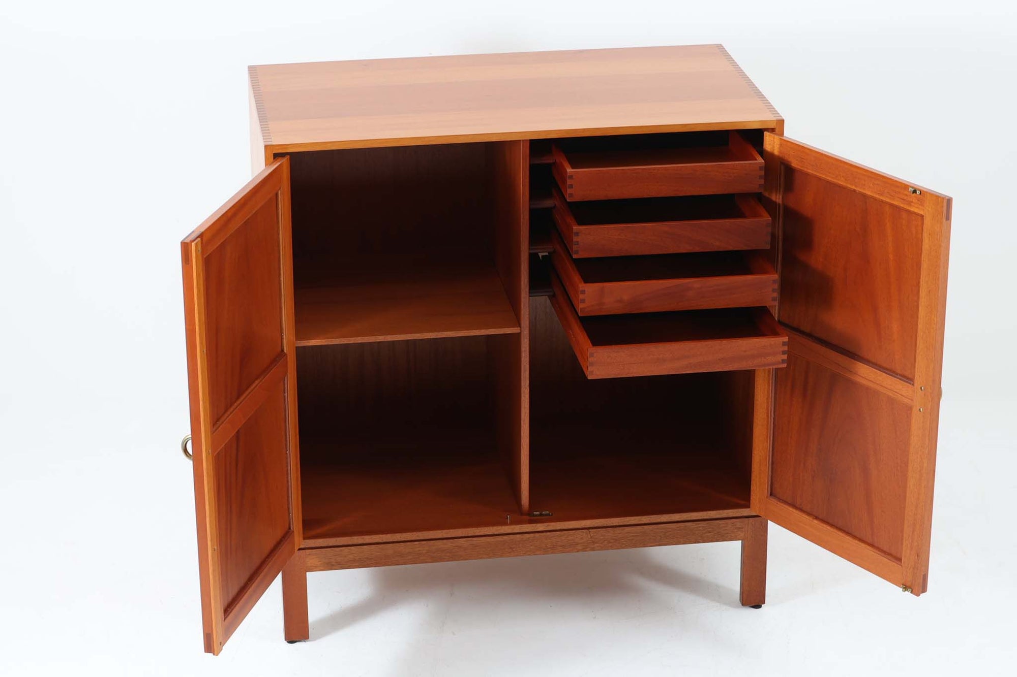 ビンテージ北欧家具の名門、デンマークのSoborg mobler社が手掛けたキャビネットです。デザイナーはChristian Hvidt（クリスチャン・ヴィッツ）。上質なマホガニー無垢材を贅沢に使用し、美しい木目と落ち着いた色合いが特徴的です。扉の意匠は4枚のパネルで構成され、シンプルながらも端正な印象を与えます。内部は左側に棚板、右側に引き出しを配置した実用的な収納設計。特にフレームや引き出しには指物（さしもの）による堅牢な組み方が施されており、デンマークの確かな家具製作技術を感じられます。脚付きのスタイルは床との間に適度な空間を作り出し、重厚な本体でありながら軽やかな印象を演出しています。リビングやダイニングルームでの使用に最適な、機能性とデザイン性を兼ね備えた逸品です。