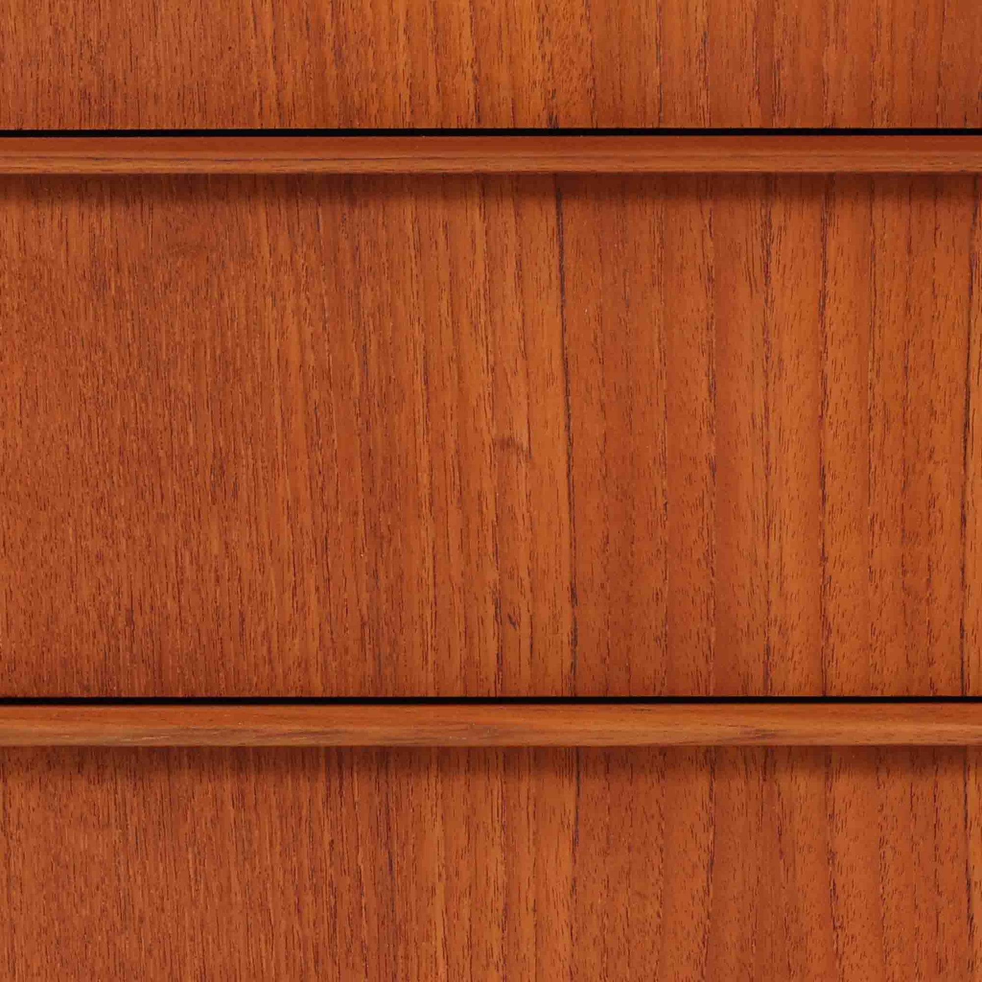 チーク材の美しい木目が前面に現れた、デンマークで作られた4段チェストです。直線を基調とした端正な佇まいと、引き出し上部に取手を設けたミニマルな構造が北欧らしい洗練を感じさせます。脚部は細身で床からの抜け感があり、空間を軽やかに演出します。収納力の高い4段構成で、衣類や書類、小物整理まで幅広く対応し、リビングや寝室、書斎など多様なシーンで活躍します。経年により深みを増したチークの色合いと質感は、ビンテージ家具ならではの魅力です。