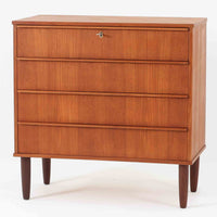チーク材の美しい木目が前面に現れた、デンマークで作られた4段チェストです。直線を基調とした端正な佇まいと、引き出し上部に取手を設けたミニマルな構造が北欧らしい洗練を感じさせます。脚部は細身で床からの抜け感があり、空間を軽やかに演出します。収納力の高い4段構成で、衣類や書類、小物整理まで幅広く対応し、リビングや寝室、書斎など多様なシーンで活躍します。経年により深みを増したチークの色合いと質感は、ビンテージ家具ならではの魅力です。