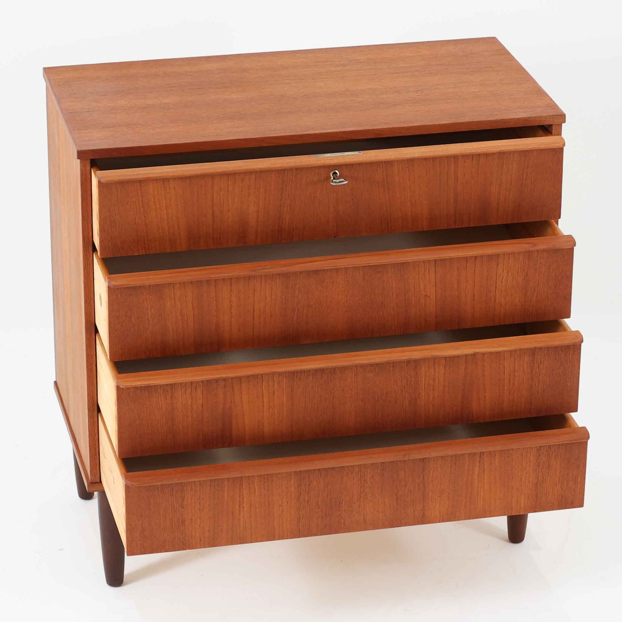 チーク材の美しい木目が前面に現れた、デンマークで作られた4段チェストです。直線を基調とした端正な佇まいと、引き出し上部に取手を設けたミニマルな構造が北欧らしい洗練を感じさせます。脚部は細身で床からの抜け感があり、空間を軽やかに演出します。収納力の高い4段構成で、衣類や書類、小物整理まで幅広く対応し、リビングや寝室、書斎など多様なシーンで活躍します。経年により深みを増したチークの色合いと質感は、ビンテージ家具ならではの魅力です。