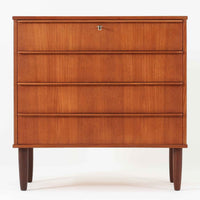 チーク材の美しい木目が前面に現れた、デンマークで作られた4段チェストです。直線を基調とした端正な佇まいと、引き出し上部に取手を設けたミニマルな構造が北欧らしい洗練を感じさせます。脚部は細身で床からの抜け感があり、空間を軽やかに演出します。収納力の高い4段構成で、衣類や書類、小物整理まで幅広く対応し、リビングや寝室、書斎など多様なシーンで活躍します。経年により深みを増したチークの色合いと質感は、ビンテージ家具ならではの魅力です。