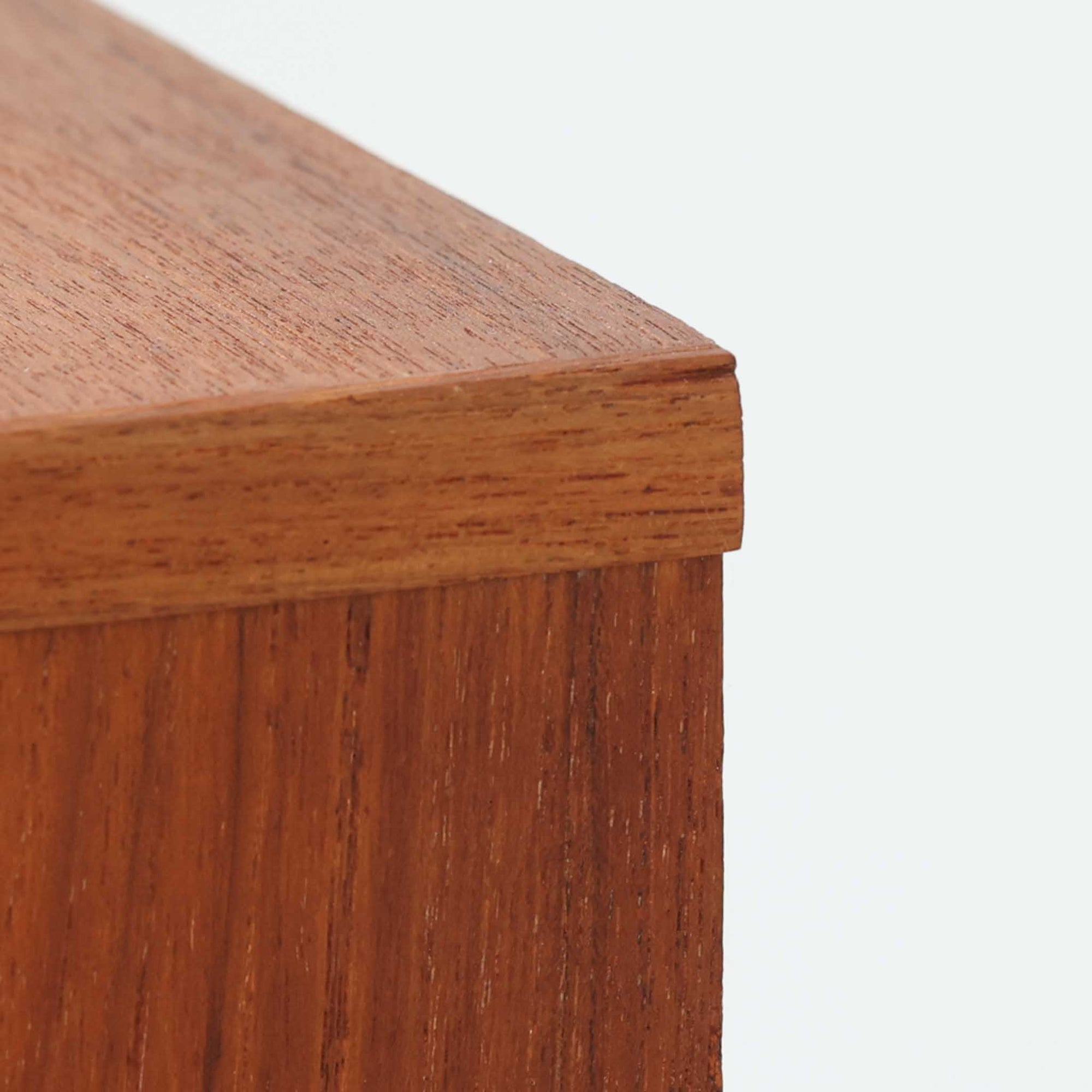 チーク材の美しい木目が前面に現れた、デンマークで作られた4段チェストです。直線を基調とした端正な佇まいと、引き出し上部に取手を設けたミニマルな構造が北欧らしい洗練を感じさせます。脚部は細身で床からの抜け感があり、空間を軽やかに演出します。収納力の高い4段構成で、衣類や書類、小物整理まで幅広く対応し、リビングや寝室、書斎など多様なシーンで活躍します。経年により深みを増したチークの色合いと質感は、ビンテージ家具ならではの魅力です。