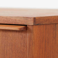 チーク材の美しい木目が前面に現れた、デンマークで作られた4段チェストです。直線を基調とした端正な佇まいと、引き出し上部に取手を設けたミニマルな構造が北欧らしい洗練を感じさせます。脚部は細身で床からの抜け感があり、空間を軽やかに演出します。収納力の高い4段構成で、衣類や書類、小物整理まで幅広く対応し、リビングや寝室、書斎など多様なシーンで活躍します。経年により深みを増したチークの色合いと質感は、ビンテージ家具ならではの魅力です。