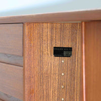 Gunni Omannがデザインし、Omann Jun社によって製造されたModel 18は、洗練されたラインと実用性を兼ね備えた北欧ビンテージの名作サイドボードです。チーク材の美しい木目が前面に広がり、引き出しとスライド扉の組み合わせが高い収納力を実現しています。特に繊細に削り出された取手や先細りの脚部が、軽やかで彫刻的な印象を与え、空間を上質に演出します。幅200cmのサイズ感は、リビングやダイニングの主役として活躍する存在感ある一台です。