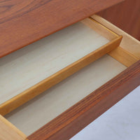 Gunni Omannがデザインし、Omann Jun社によって製造されたModel 18は、洗練されたラインと実用性を兼ね備えた北欧ビンテージの名作サイドボードです。チーク材の美しい木目が前面に広がり、引き出しとスライド扉の組み合わせが高い収納力を実現しています。特に繊細に削り出された取手や先細りの脚部が、軽やかで彫刻的な印象を与え、空間を上質に演出します。幅200cmのサイズ感は、リビングやダイニングの主役として活躍する存在感ある一台です。