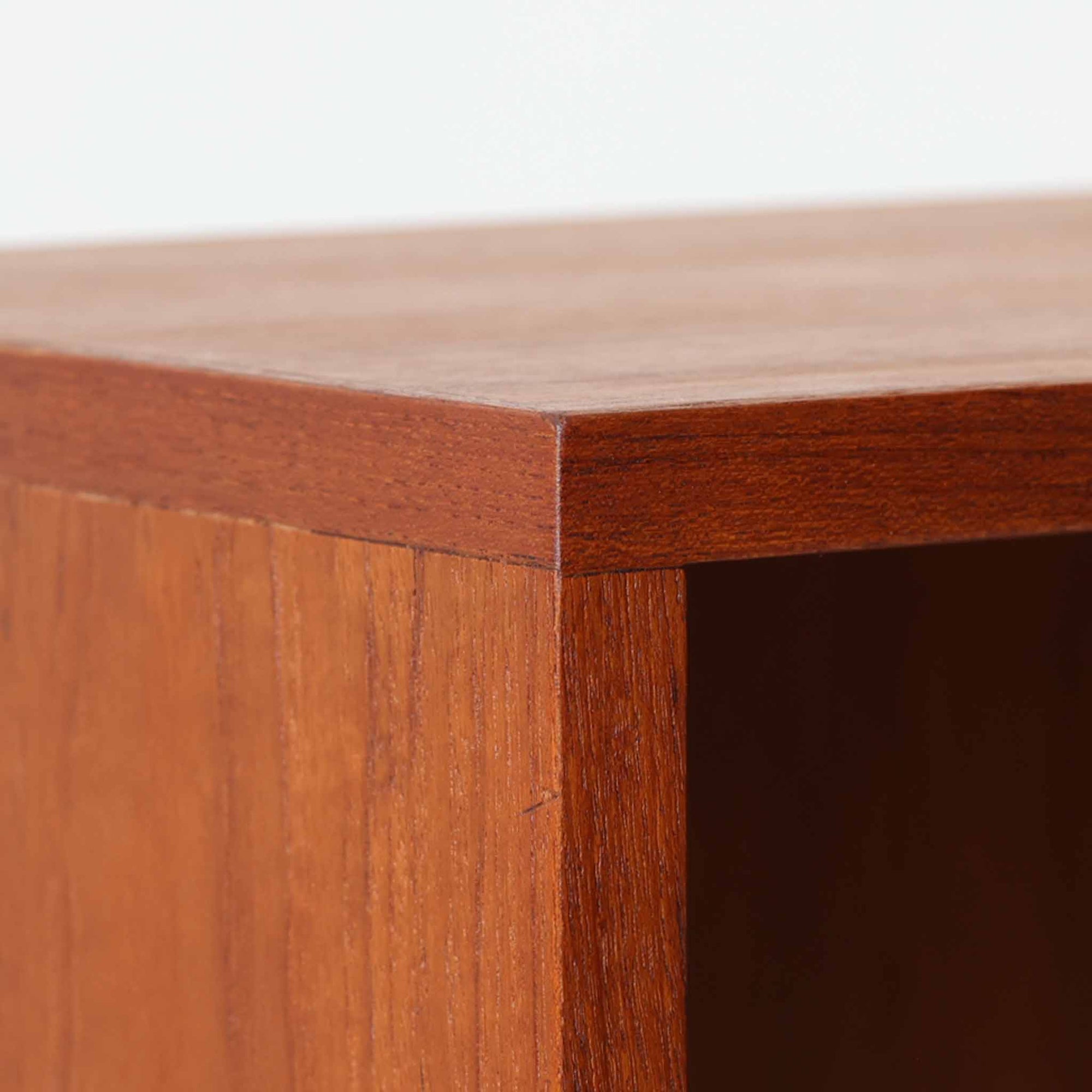 Bjerringbro Savvaerkによるチーク材キャビネットは、上下に分かれた構成と可動棚を備えた収納力の高さが魅力です。上段は3段のシェルフ、下段は珍しいポケットドア構造の扉内にA4サイズの書類が収納可能な引き出し型トレイが8段並び、書類や小物の整理に適しています。直線的で端正なフォルムと、チーク材の木目が美しく調和した佇まいは、北欧ビンテージらしい実用性と美しさを兼ね備えた逸品です。