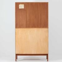 Bjerringbro Savvaerkによるチーク材キャビネットは、上下に分かれた構成と可動棚を備えた収納力の高さが魅力です。上段は3段のシェルフ、下段は珍しいポケットドア構造の扉内にA4サイズの書類が収納可能な引き出し型トレイが8段並び、書類や小物の整理に適しています。直線的で端正なフォルムと、チーク材の木目が美しく調和した佇まいは、北欧ビンテージらしい実用性と美しさを兼ね備えた逸品です。