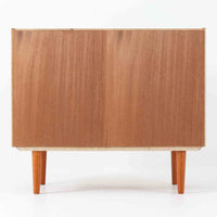 幅88cmとコンパクトなサイズ感が魅力のこちらのボードは、チーク材の温もりある質感と直線的なデザインが調和した北欧ビンテージ品です。前面にはスライド扉を備え、内部は左右に仕切られた収納スペースで、日用品の整理や見せたくない物の収納にも最適です。脚部にはテーパー加工が施され、軽やかな印象を与えつつ安定感も確保。省スペースに置けるため、玄関や寝室など限られた空間にもフィットし、日常に使いやすい一台です。