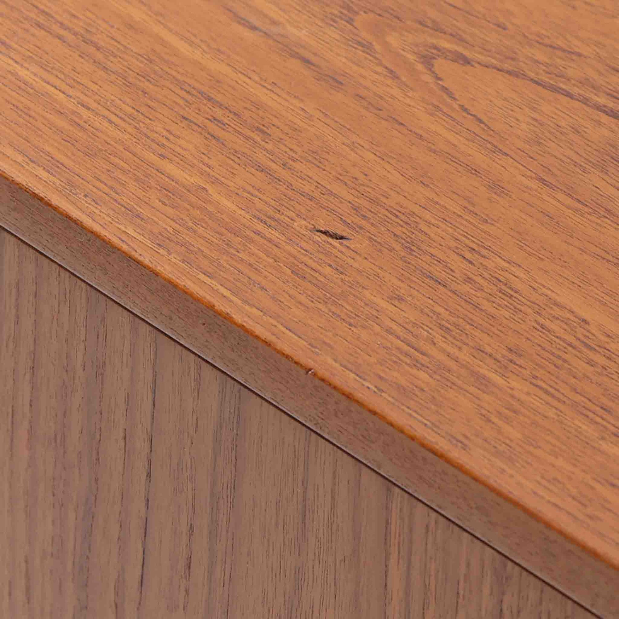 Hans J. Wegner（ハンス・J・ウェグナー）によってデザインされ、RY Mobler社により製造されたこちらのキャビネットは、美しいチーク材と実用的な構造が融合した北欧ビンテージ家具の名作です。扉にはチーク材特有の深い木目が活かされ、中央の控えめな金属製ハンドルがアクセントとなっています。内部は可動棚付きの2室構成で、食器類や書類、小物の整理にも適した収納力を備えています。注目すべきは、足摺にあたる下部のパーツにオーク材が使用されている点で、異なる木材の組み合わせが上質なコントラストを生み出しています。背面には「RY」ロゴと「27 APR 1959」のスタンプが残っており、当時のオリジナルであることが確認できます。リビングやダイニング、書斎などさまざまな空間で、温もりと凛とした佇まいを演出してくれる北欧ビンテージ家具らしい一台です。