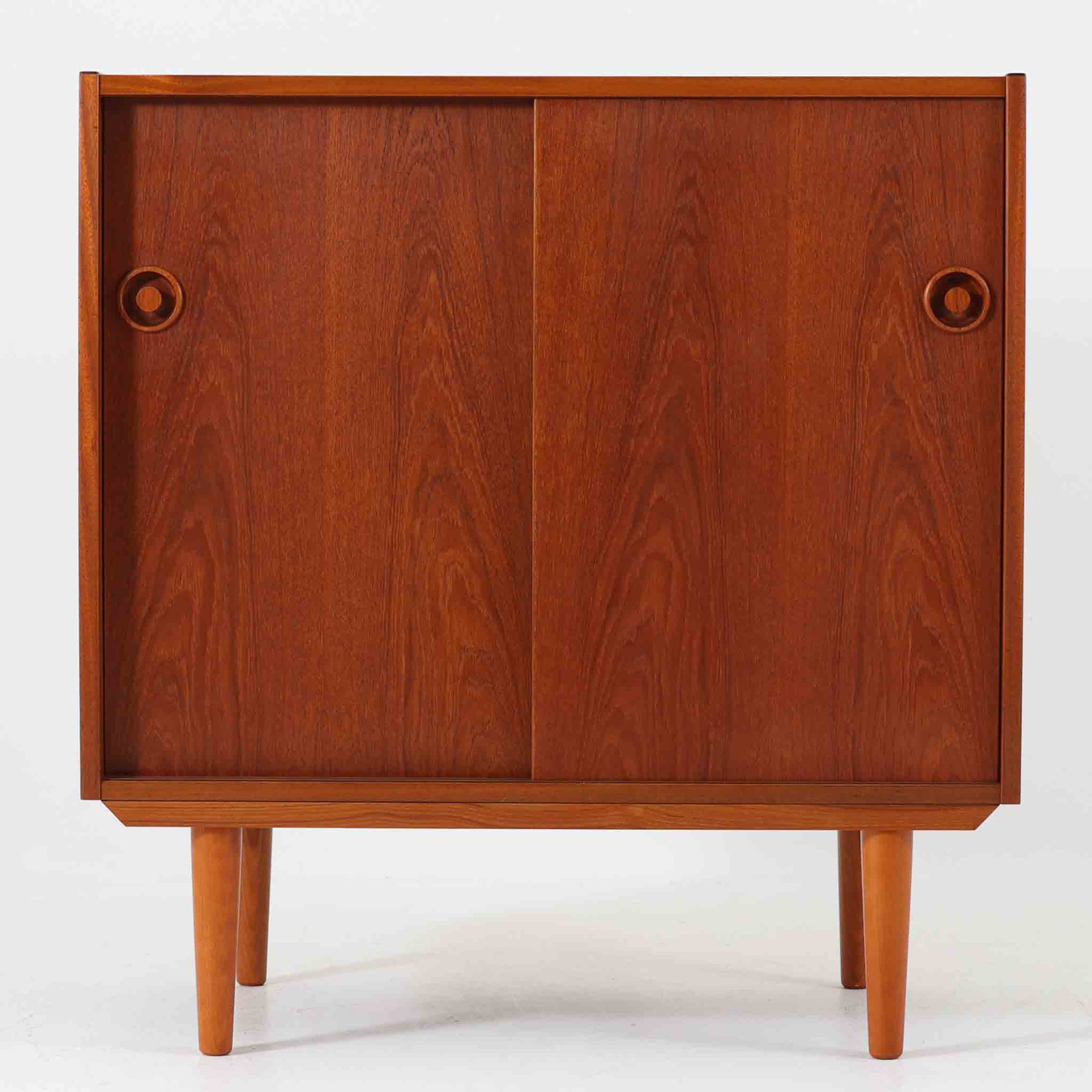 チーク材を贅沢に用いたこちらのボードは、幅80cmのコンパクトなサイズ感とシンプルで洗練されたデザインが魅力の北欧ビンテージ家具です。美しい木目が際立つスライド扉や、丸型の掘り込み取手が程よいアクセントとなっており、収納家具としての実用性はもちろん、インテリアとしても高い完成度を誇ります。リビングや寝室、玄関まわりなど限られたスペースにも取り入れやすく、日常の暮らしに上質な雰囲気を添える一台です。