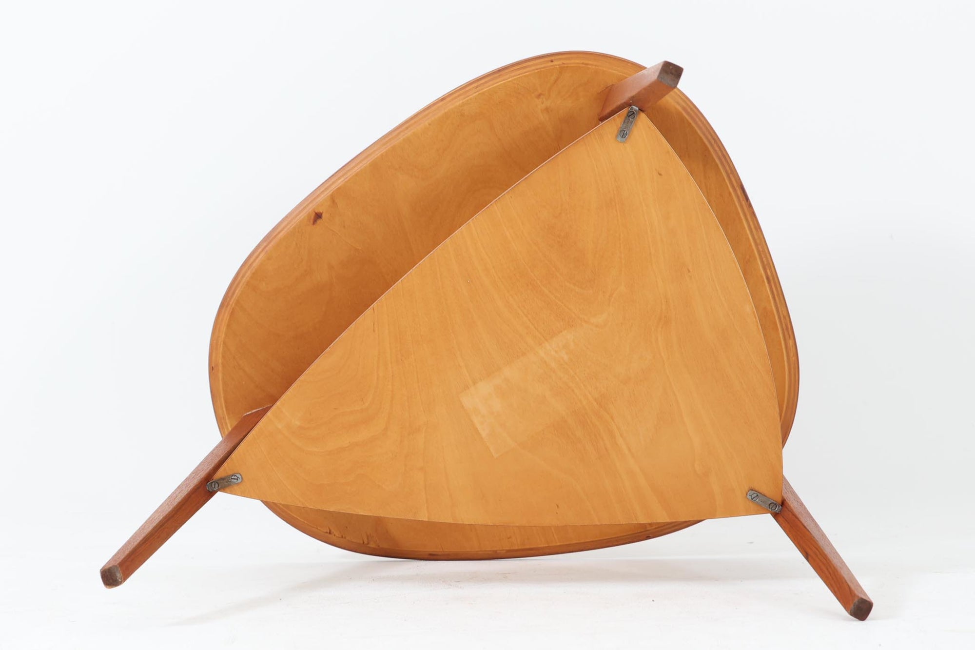 Holger Georg Jensen（ホルガー・ジョージ・イェンセン）によってデザインされ、Kubus moblerから製造されたデンマーク製ビンテージのサイドテーブルです。有機的な曲線を描く天板と、それを支える3本脚の構造が美しいバランスを保っています。天板下には同形状の棚板が設けられており、雑誌や小物の収納にも便利です。素材には艶やかなチーク材が用いられ、天板の木目の美しさも際立っています。北欧モダンを感じさせる上品な佇まいで、ソファサイドやベッドサイドにおすすめの一台です。