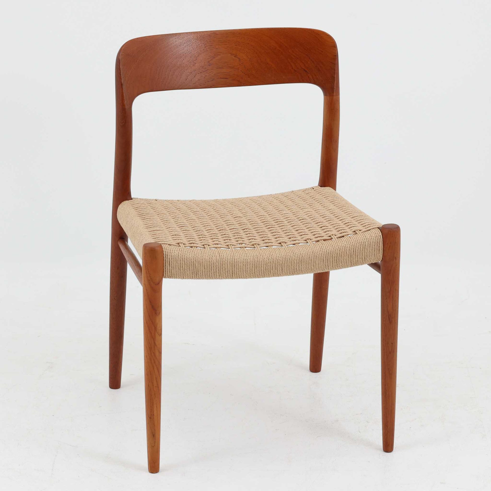 Niels O. MollerによるModel 75 ダイニングチェア。美しい曲線を描く背もたれと、繊細なラインで構成されたフレームが印象的な北欧デザインです。チーク材ならではの深みある木目と、丁寧に編み込まれたペーパーコード座面が調和し、軽やかさと上質感を兼ね備えています。背中をやさしく支える有機的なフォルムと高い職人技が感じられる構造で、ダイニングはもちろん書斎や空間のアクセントチェアとしても活躍。経年変化による味わいも魅力の北欧ビンテージを代表する一脚です。
