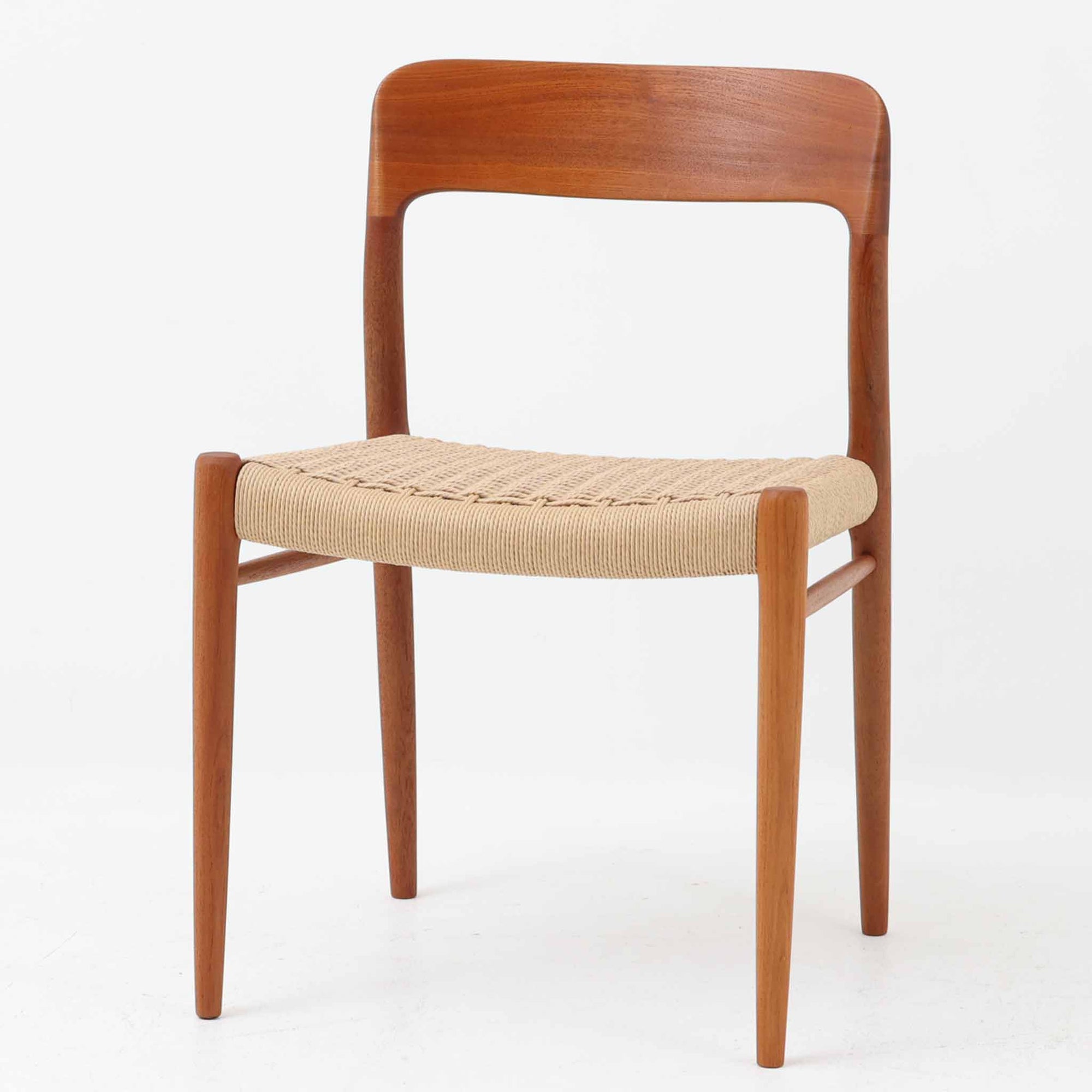 Niels Otto Mollerによってデザインされ、J.L. Mollers Mobelfabrikより製造されたModel 75は、流れるようなラインのチークフレームと、手作業で編み込まれたペーパーコードの座面が美しく調和したダイニングチェアです。背もたれの柔らかな曲線が身体に心地よくフィットし、無駄のないフォルムが北欧ビンテージならではの気品を漂わせます。年月を重ねて深まった木部の風合いと軽やかな佇まいが魅力で、ダイニングはもちろん、一脚で空間のアクセントにもなる上質な逸品です。ビンテージ品でのみ入手可能なチーク材のモデルです。