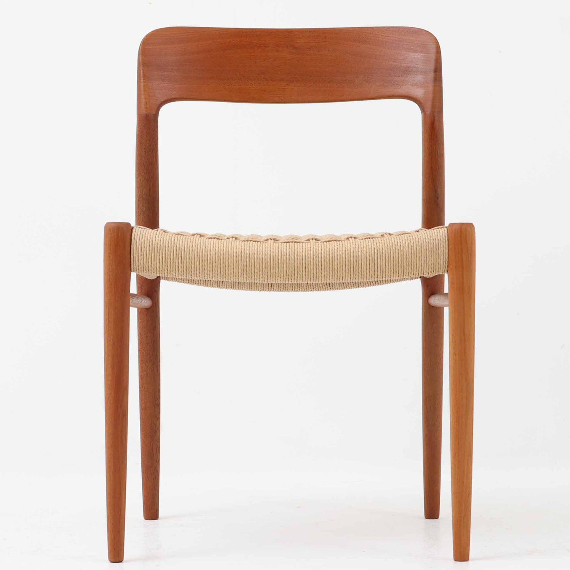 Niels Otto Mollerによってデザインされ、J.L. Mollers Mobelfabrikより製造されたModel 75は、流れるようなラインのチークフレームと、手作業で編み込まれたペーパーコードの座面が美しく調和したダイニングチェアです。背もたれの柔らかな曲線が身体に心地よくフィットし、無駄のないフォルムが北欧ビンテージならではの気品を漂わせます。年月を重ねて深まった木部の風合いと軽やかな佇まいが魅力で、ダイニングはもちろん、一脚で空間のアクセントにもなる上質な逸品です。ビンテージ品でのみ入手可能なチーク材のモデルです。