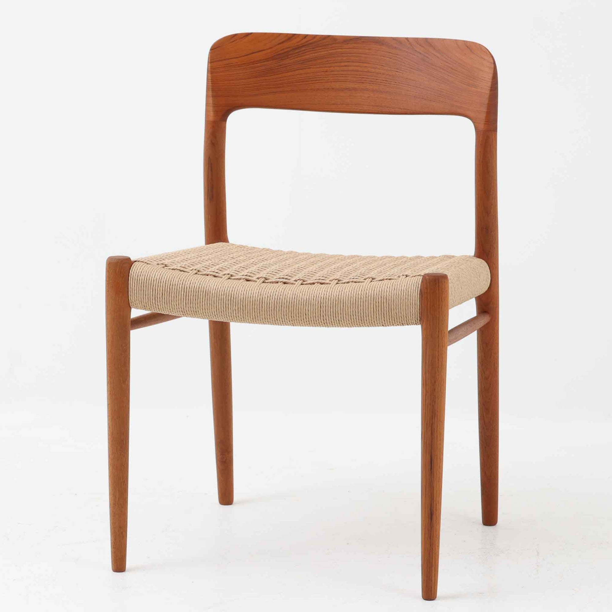 Niels Otto Mollerによってデザインされ、J.L. Mollers Mobelfabrikより製造されたModel 75は、流れるようなラインのチークフレームと、手作業で編み込まれたペーパーコードの座面が美しく調和したダイニングチェアです。背もたれの柔らかな曲線が身体に心地よくフィットし、無駄のないフォルムが北欧ビンテージならではの気品を漂わせます。年月を重ねて深まった木部の風合いと軽やかな佇まいが魅力で、ダイニングはもちろん、一脚で空間のアクセントにもなる上質な逸品です。ビンテージ品でのみ入手可能なチーク材のモデルです。