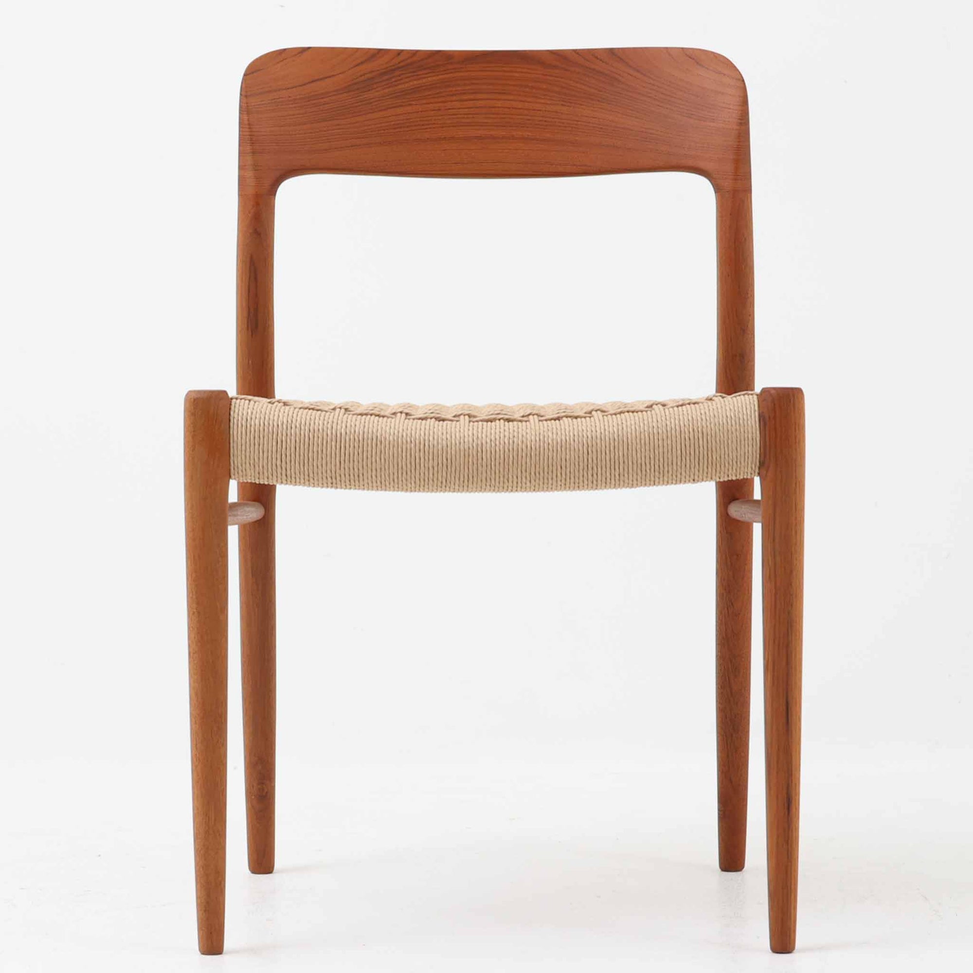 Niels Otto Mollerによってデザインされ、J.L. Mollers Mobelfabrikより製造されたModel 75は、流れるようなラインのチークフレームと、手作業で編み込まれたペーパーコードの座面が美しく調和したダイニングチェアです。背もたれの柔らかな曲線が身体に心地よくフィットし、無駄のないフォルムが北欧ビンテージならではの気品を漂わせます。年月を重ねて深まった木部の風合いと軽やかな佇まいが魅力で、ダイニングはもちろん、一脚で空間のアクセントにもなる上質な逸品です。ビンテージ品でのみ入手可能なチーク材のモデルです。