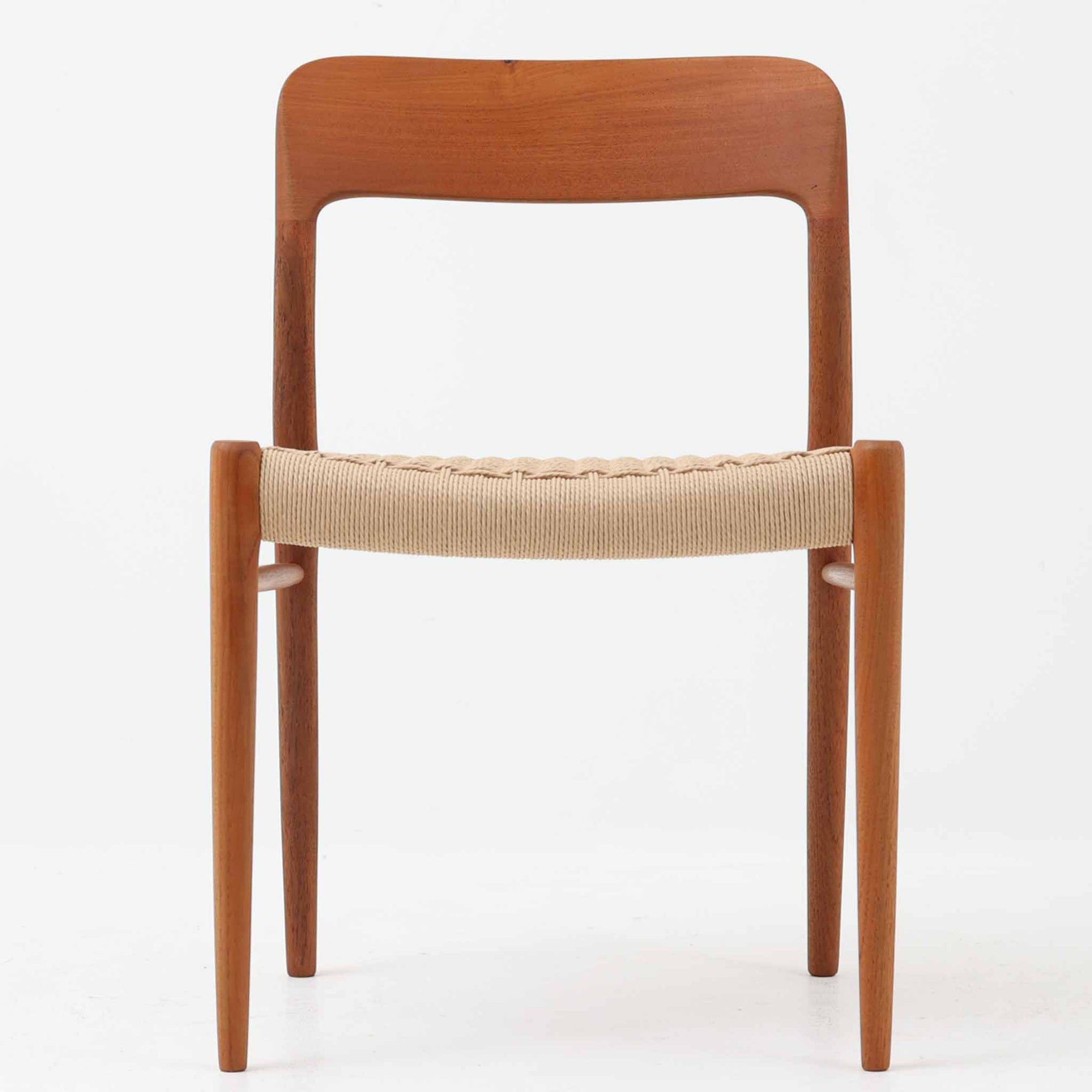 Niels Otto Mollerによってデザインされ、J.L. Mollers Mobelfabrikより製造されたModel 75は、流れるようなラインのチークフレームと、手作業で編み込まれたペーパーコードの座面が美しく調和したダイニングチェアです。背もたれの柔らかな曲線が身体に心地よくフィットし、無駄のないフォルムが北欧ビンテージならではの気品を漂わせます。年月を重ねて深まった木部の風合いと軽やかな佇まいが魅力で、ダイニングはもちろん、一脚で空間のアクセントにもなる上質な逸品です。ビンテージ品でのみ入手可能なチーク材のモデルです。