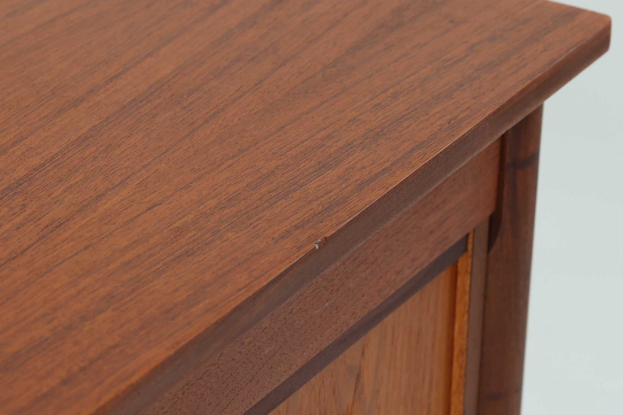 シンプルで洗練された佇まいが魅力のこちらの片袖デスクは、上質なチーク材を用いた北欧ビンテージ家具です。丸みを帯びたテーパードレッグや、緩やかにカーブした引き出しの取っ手が、温もりと職人技を感じさせるディテールとなっています。引き出しは3段構成で収納力があり、鍵付きの上段は大切な書類の保管にも最適です。コンパクトながら実用性に優れており、ワークデスクやドレッサー代わりとしてもおすすめできる逸品です。経年変化による木肌の風合いもビンテージならではの魅力で、空間に落ち着きと品格を与えてくれます。