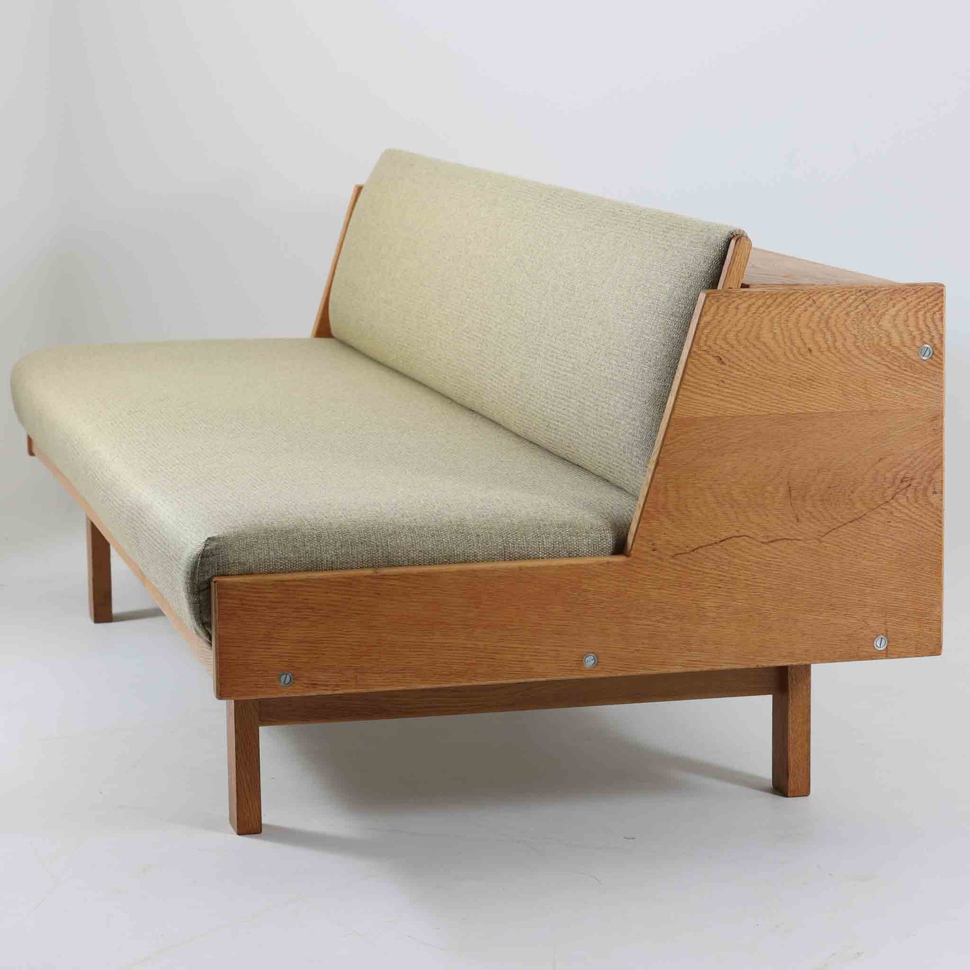 Hans J. WegnerがGetamaのためにデザインしたGE258デイベッド。オーク材の明るく上品な木肌と角脚の端正なフォルムが美しく、直線を基調としたミニマルな構造にウェグナーらしい機能美が息づいています。背もたれを倒すことでベッドとしても使用できる実用的な設計で、リビングでは洗練されたソファ、書斎やゲストルームでは簡易ベッドとしても活躍。経年により深まったオークの味わいとGetamaならではの堅牢なつくりが、北欧ビンテージらしい存在感と希少性を高める一台です。