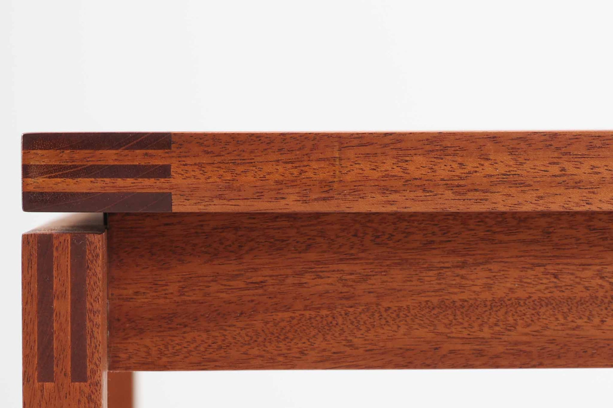 デンマークの老舗家具メーカー、munch mobler社製、Henning Jensen &amp; Torben Valeurによるデザインの北欧ビンテージテーブルです。上質なマホガニー材を使用し、滑らかな木肌と深みのある赤褐色の色合いが上品な佇まいを演出します。天板と脚部には美しい留め加工が施されており、シンプルな構造の中に職人技が光るディテールが際立ちます。幅60cm×奥行60cmのサイズ感は、ソファサイドに置くサイドテーブルとしても、リビング中央でのセンターテーブルとしても使い勝手が良く、さまざまなシーンにフィットします。ミニマルでありながらも個性を感じさせる一台をお探しの方におすすめです。