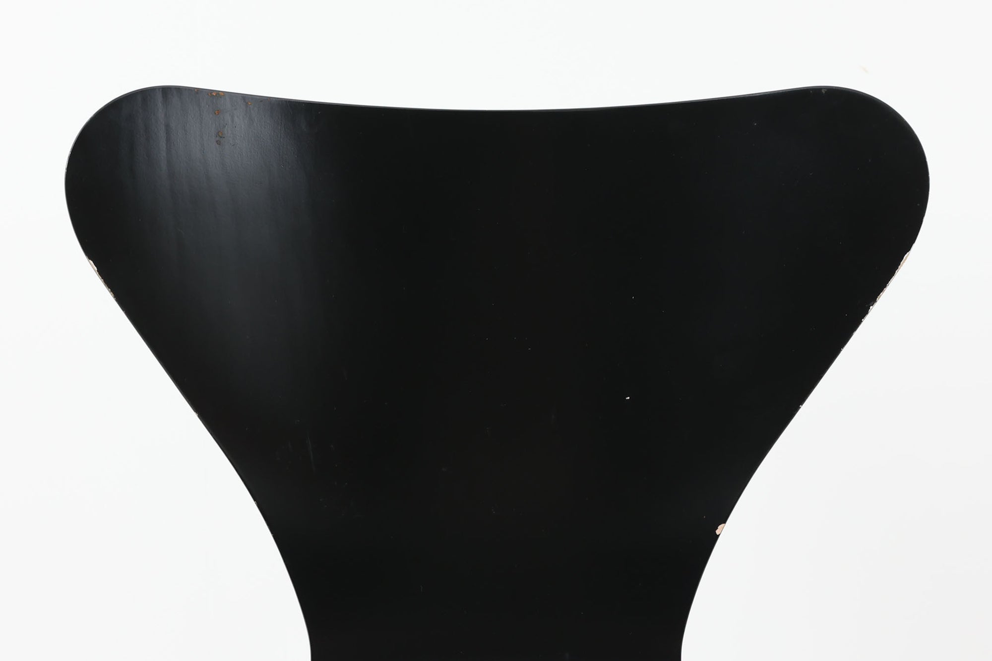 デンマークの名門Fritz Hansen社製、アルネ・ヤコブセンによる名作「セブンチェア」。こちらは2007年に製造された比較的新しいモデルです。成形合板による流れるようなフォルムが特徴で、背もたれから座面へと続く美しいカーブが、快適な座り心地を提供します。ブラックのシェルとクロームメッキの脚がモダンで洗練された印象を演出し、どんな空間にも調和するデザインです。