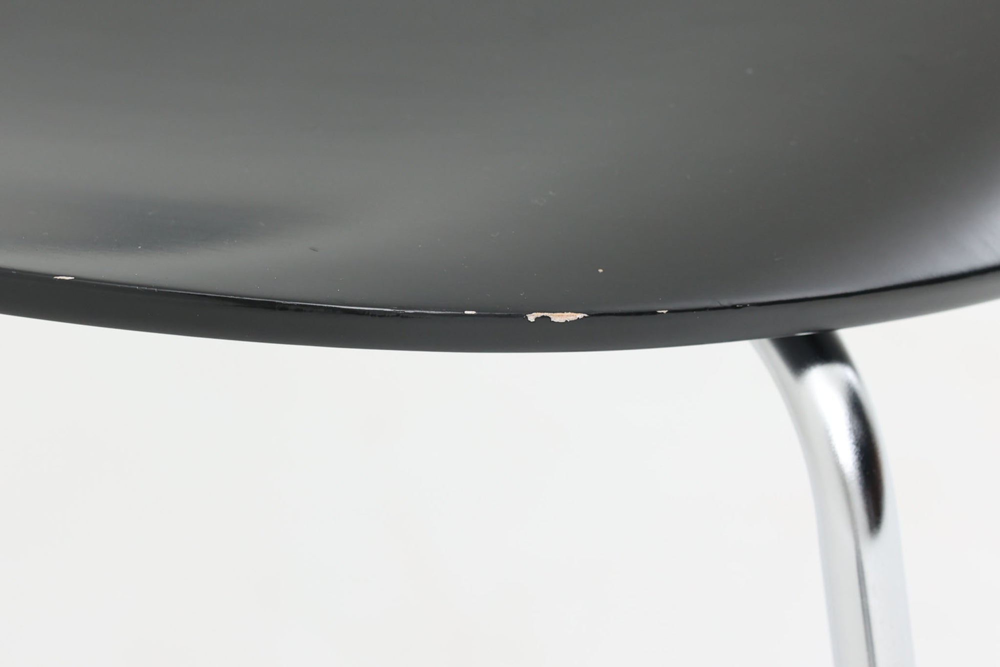 デンマークの名門Fritz Hansen社製、アルネ・ヤコブセンによる名作「セブンチェア」。こちらは2007年に製造された比較的新しいモデルです。成形合板による流れるようなフォルムが特徴で、背もたれから座面へと続く美しいカーブが、快適な座り心地を提供します。ブラックのシェルとクロームメッキの脚がモダンで洗練された印象を演出し、どんな空間にも調和するデザインです。