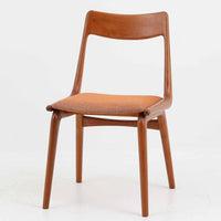 Alfred Christensen（アルフレッド・クリステンセン）によるデザインで、Slagelse Mobelvaerk社から発表されたブーメランチェアです。背から後脚にかけて滑らかに繋がるチーク材の曲線が美しく、丹念な削り出しによる立体的な造形が印象的です。オレンジ系の張地が温かみを添え、北欧らしい明るい雰囲気を演出します。軽やかなフォルムながらしっかりとした安定感があり、ダイニングチェアとしてはもちろん、デスクチェアとしてもお使いいただけます。経年により深みを増した木肌が、ビンテージならではの風格を感じさせる一脚です。