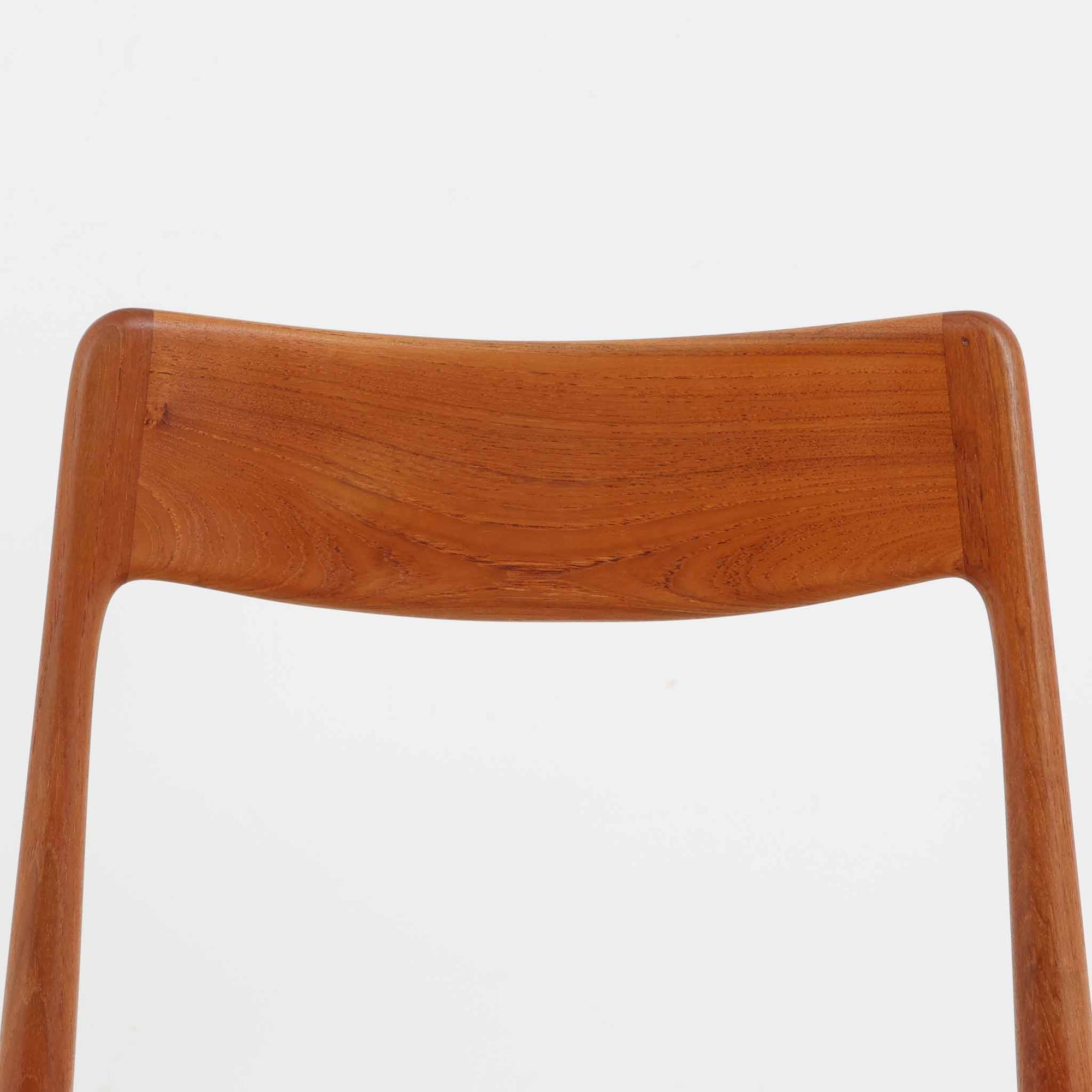 Alfred Christensen（アルフレッド・クリステンセン）によるデザインで、Slagelse Mobelvaerk社から発表されたブーメランチェアです。背から後脚にかけて滑らかに繋がるチーク材の曲線が美しく、丹念な削り出しによる立体的な造形が印象的です。オレンジ系の張地が温かみを添え、北欧らしい明るい雰囲気を演出します。軽やかなフォルムながらしっかりとした安定感があり、ダイニングチェアとしてはもちろん、デスクチェアとしてもお使いいただけます。経年により深みを増した木肌が、ビンテージならではの風格を感じさせる一脚です。