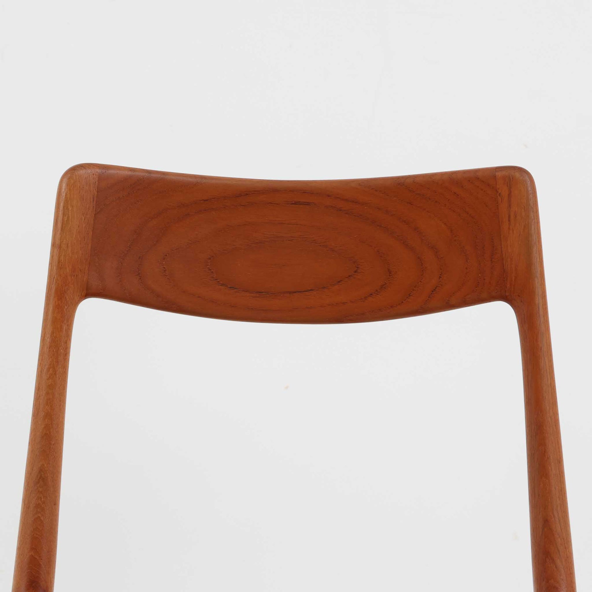 Alfred Christensen（アルフレッド・クリステンセン）によるデザインで、Slagelse Mobelvaerk社から発表されたブーメランチェアです。背から後脚にかけて滑らかに繋がるチーク材の曲線が美しく、丹念な削り出しによる立体的な造形が印象的です。オレンジ系の張地が温かみを添え、北欧らしい明るい雰囲気を演出します。軽やかなフォルムながらしっかりとした安定感があり、ダイニングチェアとしてはもちろん、デスクチェアとしてもお使いいただけます。経年により深みを増した木肌が、ビンテージならではの風格を感じさせる一脚です。