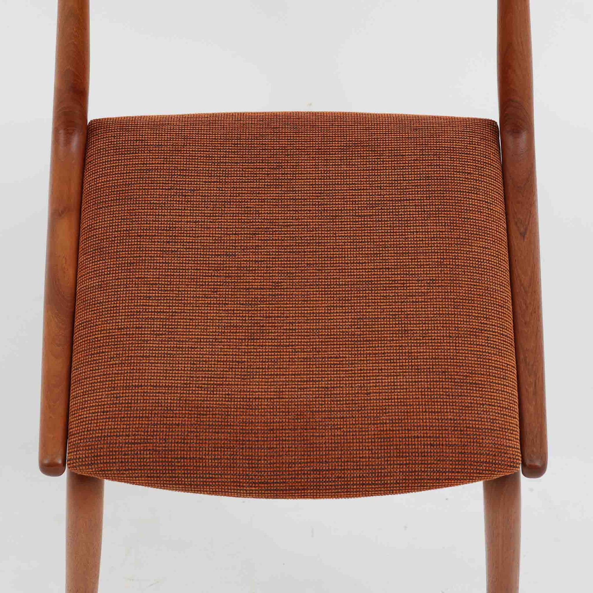 Alfred Christensen（アルフレッド・クリステンセン）によるデザインで、Slagelse Mobelvaerk社から発表されたブーメランチェアです。背から後脚にかけて滑らかに繋がるチーク材の曲線が美しく、丹念な削り出しによる立体的な造形が印象的です。オレンジ系の張地が温かみを添え、北欧らしい明るい雰囲気を演出します。軽やかなフォルムながらしっかりとした安定感があり、ダイニングチェアとしてはもちろん、デスクチェアとしてもお使いいただけます。経年により深みを増した木肌が、ビンテージならではの風格を感じさせる一脚です。