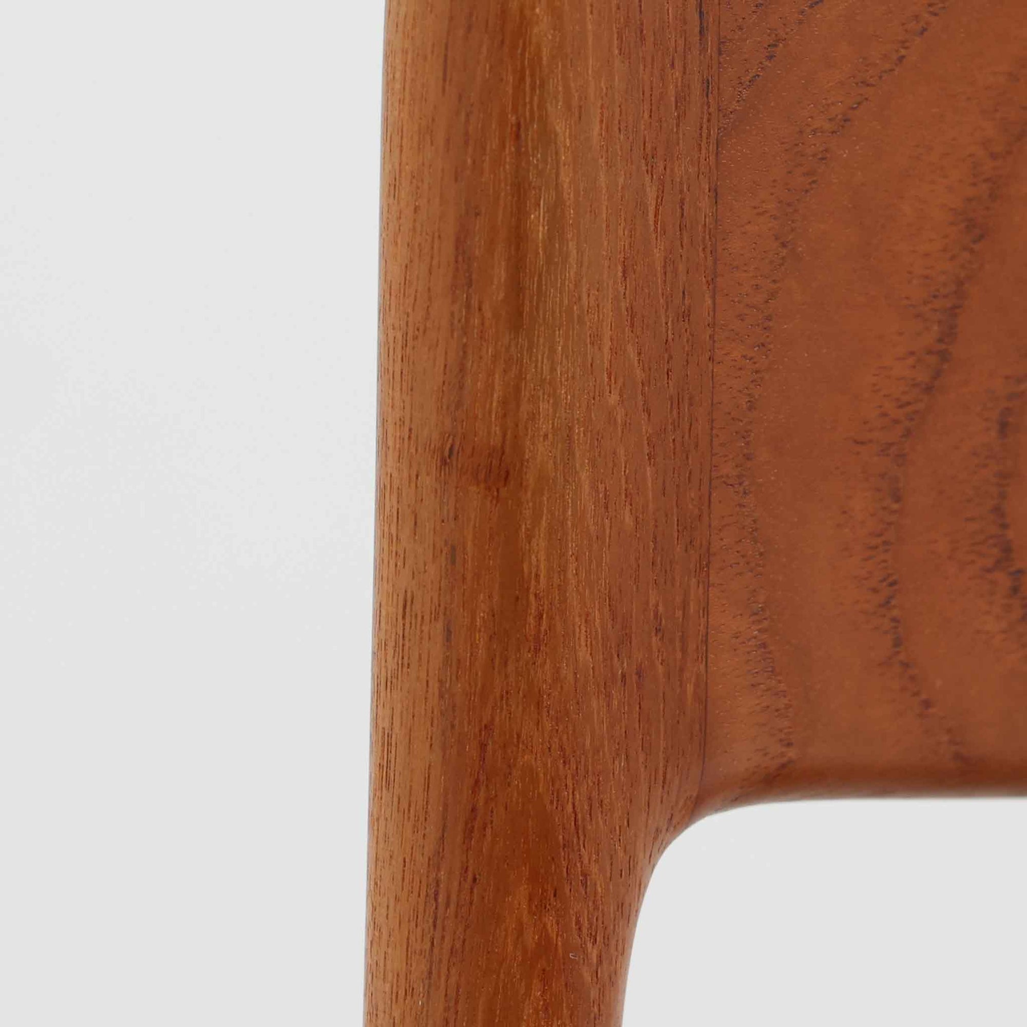 Alfred Christensen（アルフレッド・クリステンセン）によるデザインで、Slagelse Mobelvaerk社から発表されたブーメランチェアです。背から後脚にかけて滑らかに繋がるチーク材の曲線が美しく、丹念な削り出しによる立体的な造形が印象的です。オレンジ系の張地が温かみを添え、北欧らしい明るい雰囲気を演出します。軽やかなフォルムながらしっかりとした安定感があり、ダイニングチェアとしてはもちろん、デスクチェアとしてもお使いいただけます。経年により深みを増した木肌が、ビンテージならではの風格を感じさせる一脚です。