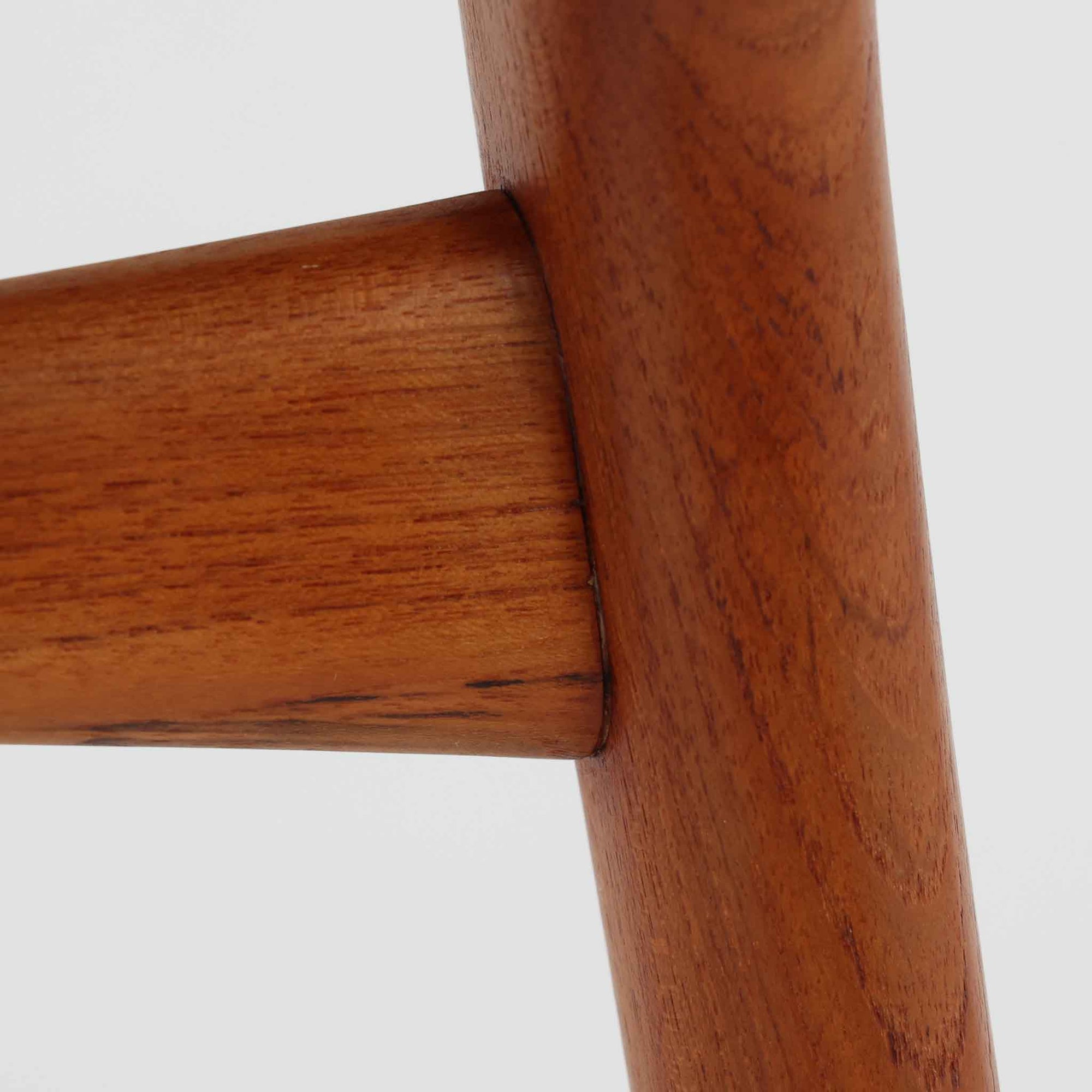 Alfred Christensen（アルフレッド・クリステンセン）によるデザインで、Slagelse Mobelvaerk社から発表されたブーメランチェアです。背から後脚にかけて滑らかに繋がるチーク材の曲線が美しく、丹念な削り出しによる立体的な造形が印象的です。オレンジ系の張地が温かみを添え、北欧らしい明るい雰囲気を演出します。軽やかなフォルムながらしっかりとした安定感があり、ダイニングチェアとしてはもちろん、デスクチェアとしてもお使いいただけます。経年により深みを増した木肌が、ビンテージならではの風格を感じさせる一脚です。