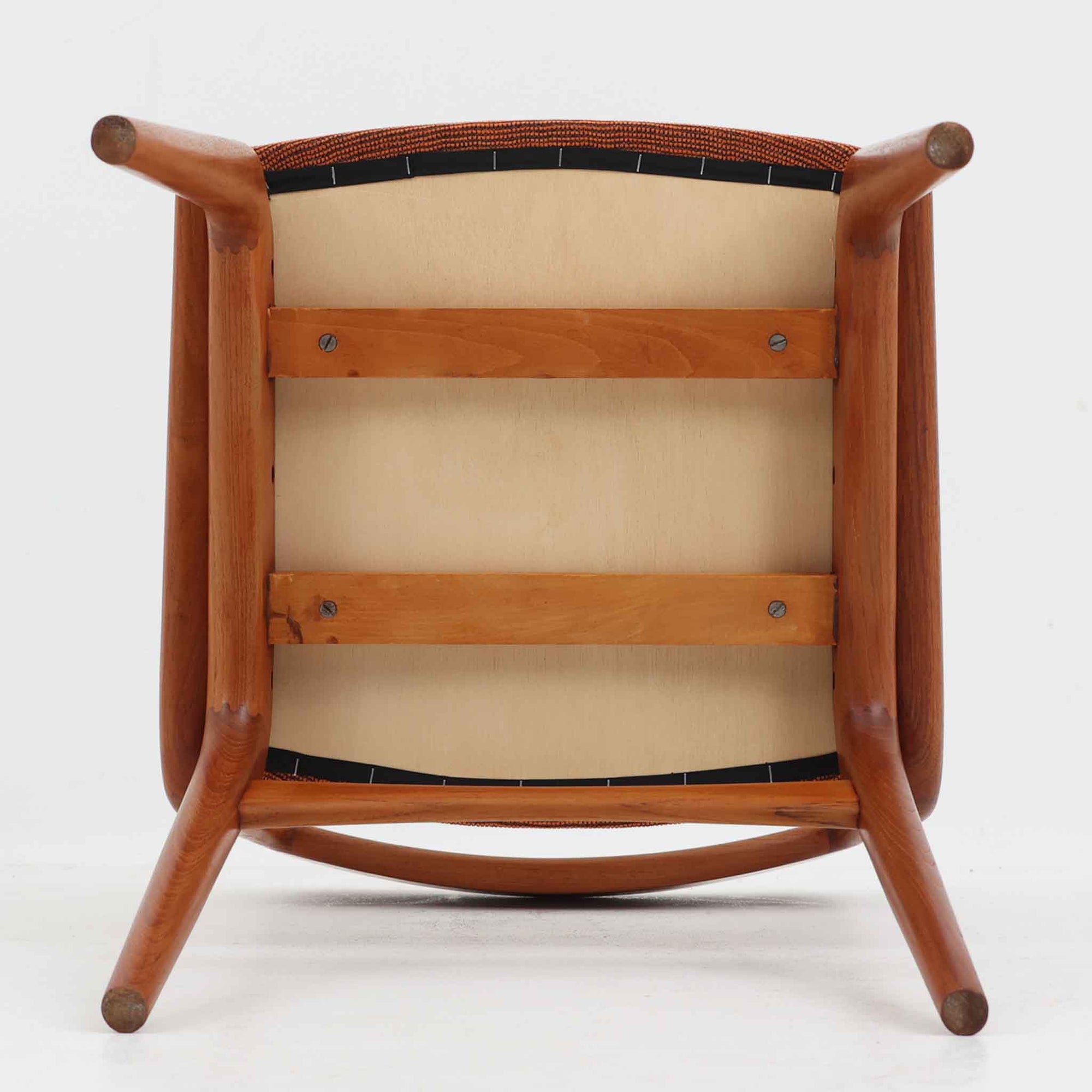 Alfred Christensen（アルフレッド・クリステンセン）によるデザインで、Slagelse Mobelvaerk社から発表されたブーメランチェアです。背から後脚にかけて滑らかに繋がるチーク材の曲線が美しく、丹念な削り出しによる立体的な造形が印象的です。オレンジ系の張地が温かみを添え、北欧らしい明るい雰囲気を演出します。軽やかなフォルムながらしっかりとした安定感があり、ダイニングチェアとしてはもちろん、デスクチェアとしてもお使いいただけます。経年により深みを増した木肌が、ビンテージならではの風格を感じさせる一脚です。