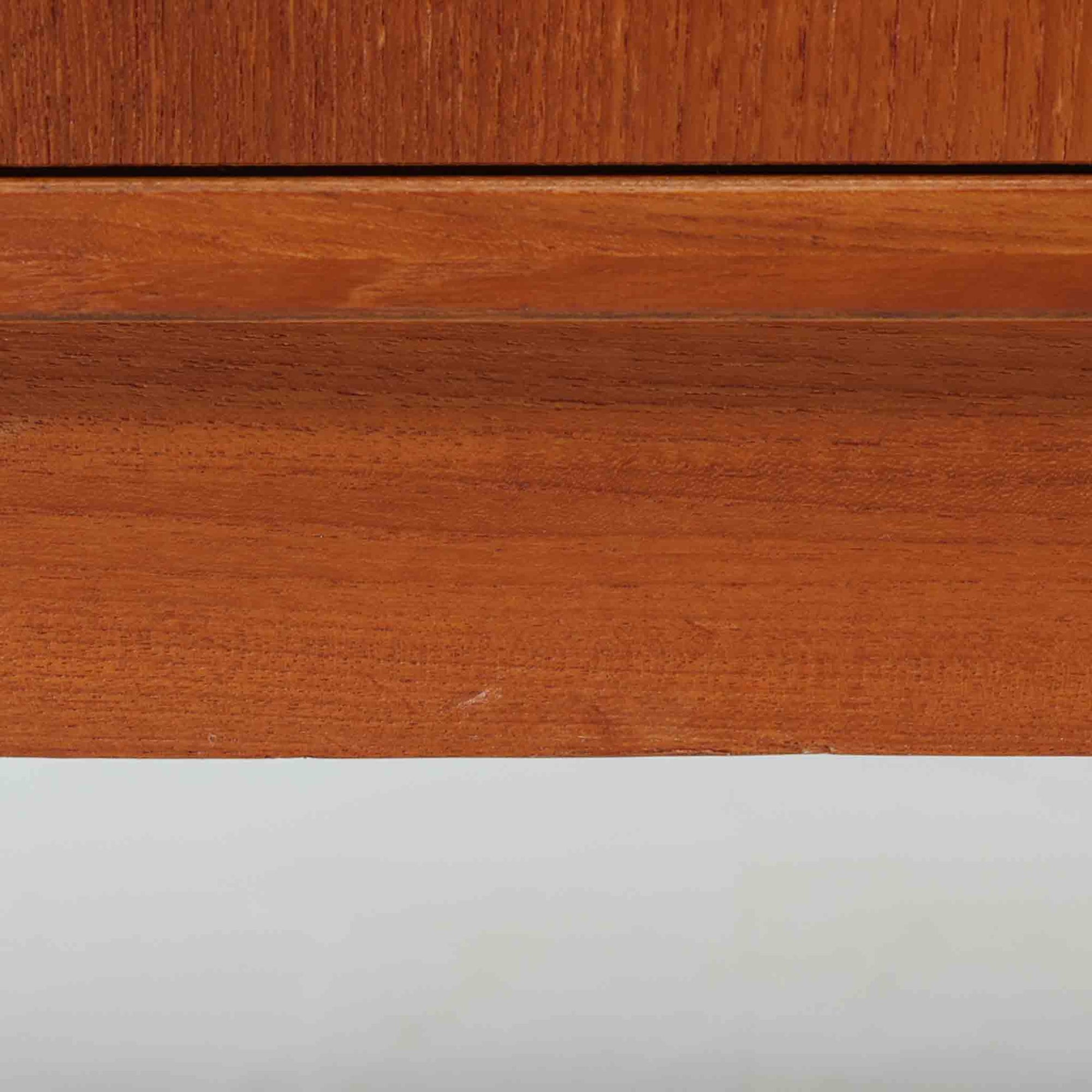 Domino Mobler社製の幅182cmのボードは、上質なチーク材を用いた美しい木目と、左右の開き戸と中央の引き出しという機能的な構成が魅力の北欧ビンテージ家具です。丸みのあるスクエア取手や脚部のすっきりとしたラインが、端正なフォルムを引き立てつつ温かみも感じさせます。収納力にも優れ、リビングやダイニングで食器や日用品を収めるサイドボードとしてはもちろん、テレビボードとしても活躍する汎用性の高い一台です。