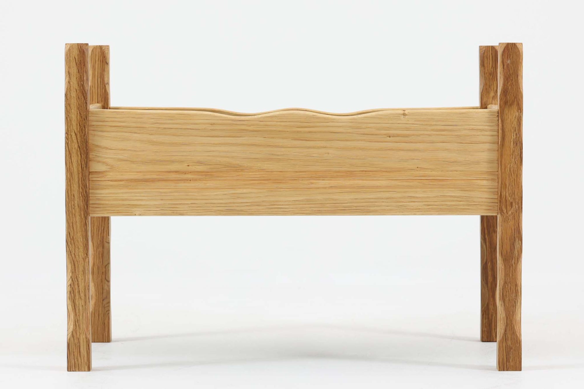 デンマーク製のビンテージプランターです。オーク材を使用し、自然な木目と素材感を活かしたデザインが特徴的です。脚部は不規則な表情を持つ無垢材を使用し、オーガニックな印象を演出。本体は美しい木目のオーク材で構成され、内部には緑色のトレイが備え付けられています。波打つような上部のラインは、無機質になりがちなプランターに優しい表情を与えています。北欧デザインらしい、自然との調和を意識した佇まいは、観葉植物や季節の花々を引き立てる上質なプランターとして、現代のインテリアにも自然に溶け込むのではないでしょうか。