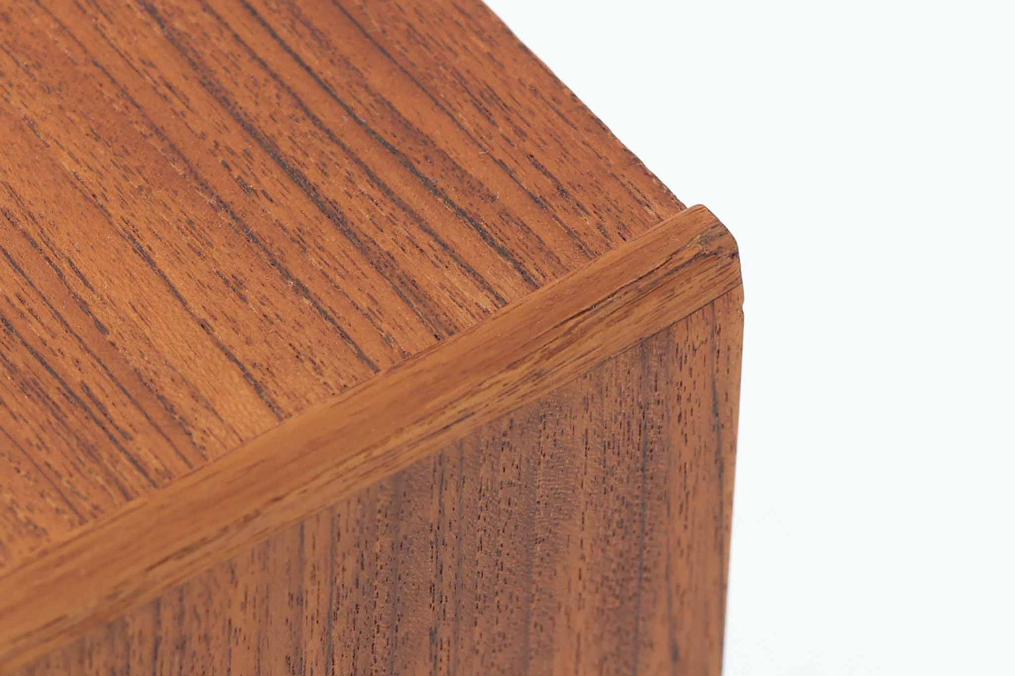 デンマークで製造されたヴィンテージのサイドチェスト。温もりのあるチーク材を用いた本体に、先細りの丸脚を組み合わせた軽やかな佇まいが魅力です。引き出し1杯に加え、下部にはオープンスペースを備えており、リモコンや文庫本などをすぐに取り出せる実用的な構造。天板や側面にはすっきりとした面取りが施され、シンプルなデザインの中に丁寧な仕事が感じられます。北欧らしいあたたかみと実用性を兼ね備えた一台。ベッドサイドはもちろん、リビングや玄関先など、暮らしのさまざまな場面で活躍します。