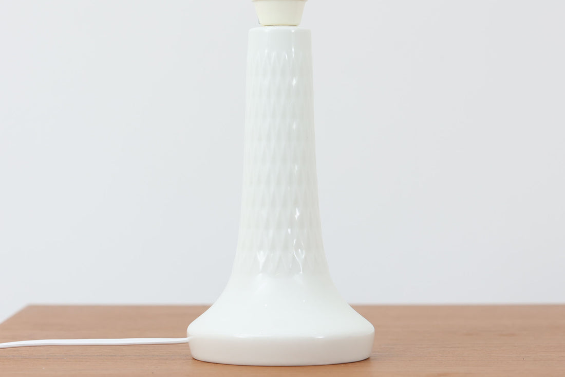 Royal CopenhagenがLe Klintのために製作したテーブルランプ。デザイナーはTorkil Olsen。艶のある白磁に繊細な凹凸模様が施され、上品でモダンな佇まいです。明るく清潔感のある印象で、どんな空間にも馴染みます。シェードには新品のリネン製を合わせており、やわらかな灯りが広がります。