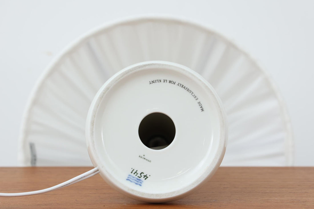 Royal CopenhagenがLe Klintのために製作したテーブルランプ。デザイナーはTorkil Olsen。艶のある白磁に繊細な凹凸模様が施され、上品でモダンな佇まいです。明るく清潔感のある印象で、どんな空間にも馴染みます。シェードには新品のリネン製を合わせており、やわらかな灯りが広がります。