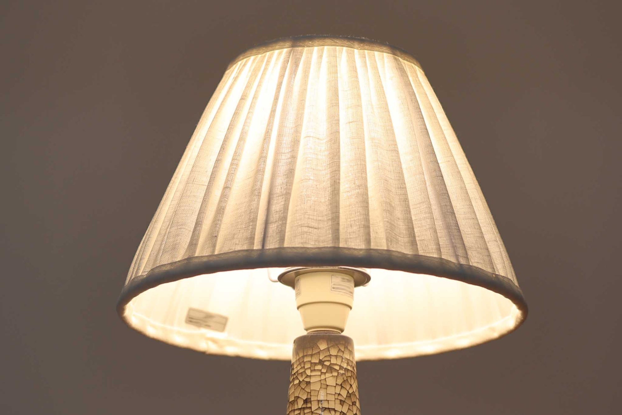 デンマーク・ボーンホルム島の老舗陶器メーカー、michael Andersen &amp; Sonによるテーブルランプ。細やかな貫入模様と深みのある釉薬の色合いが特徴で、ベース部分は温かみのあるクラフト感を漂わせています。シェードは新品のリネン製で、やさしく光を拡散し、空間に柔らかな雰囲気をもたらします。北欧ヴィンテージらしい造形美と素材感を楽しめる一点です。